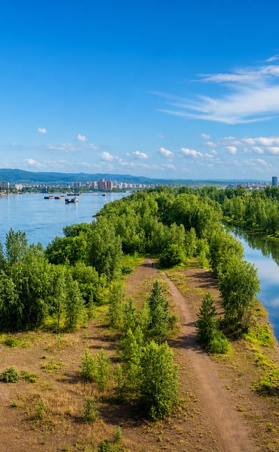 Krasnoyarsk seen across the Yenisei river and a wooded island, with the city and hills on the far bank