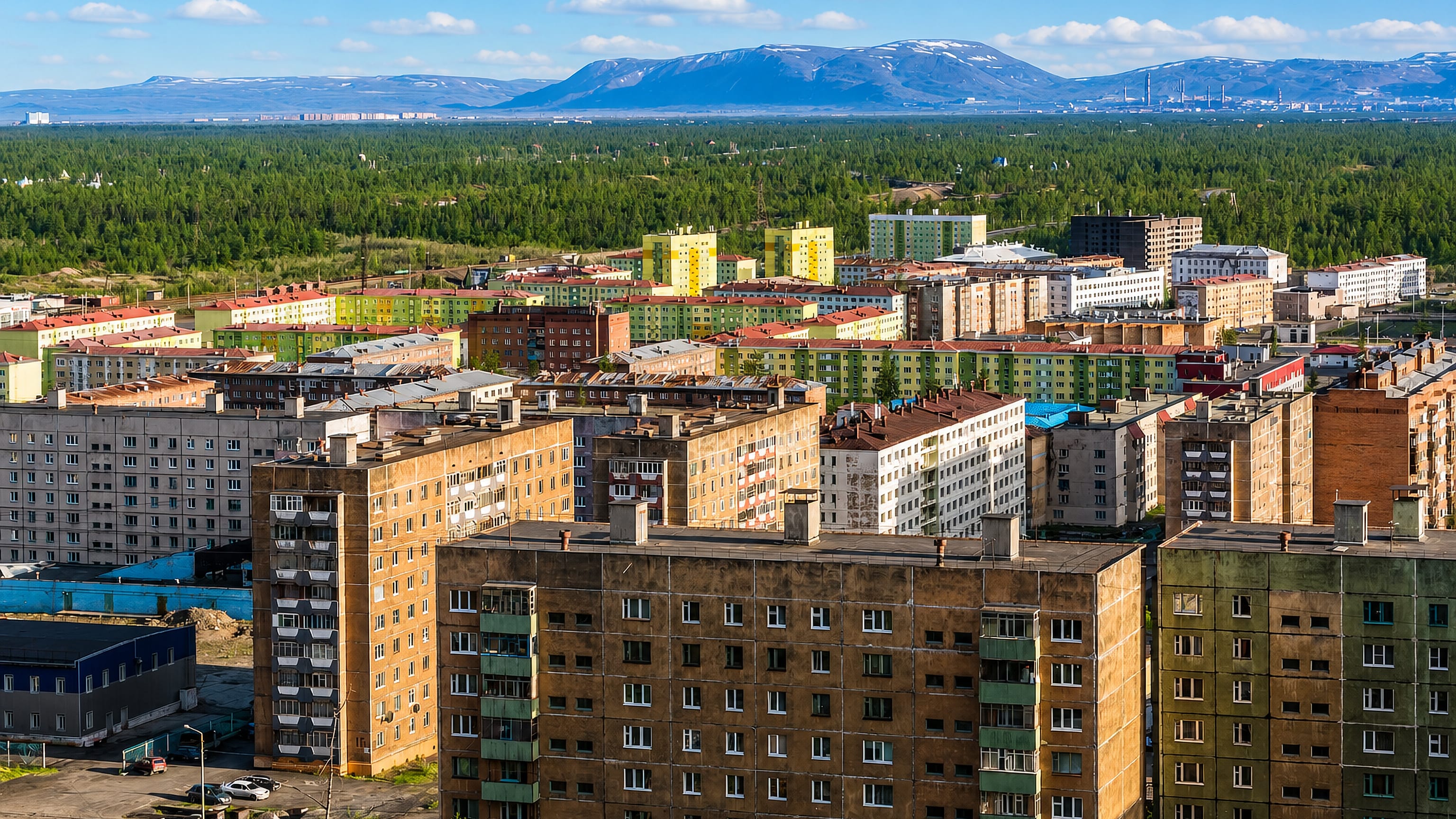 Colourful Soviet-era apartment blocks in Talnakh, Russia, backed by taiga and the Putorana plateau.
