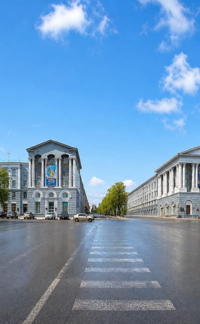 Wide central Kursk square framed by neoclassical columned buildings under a bright blue sky.