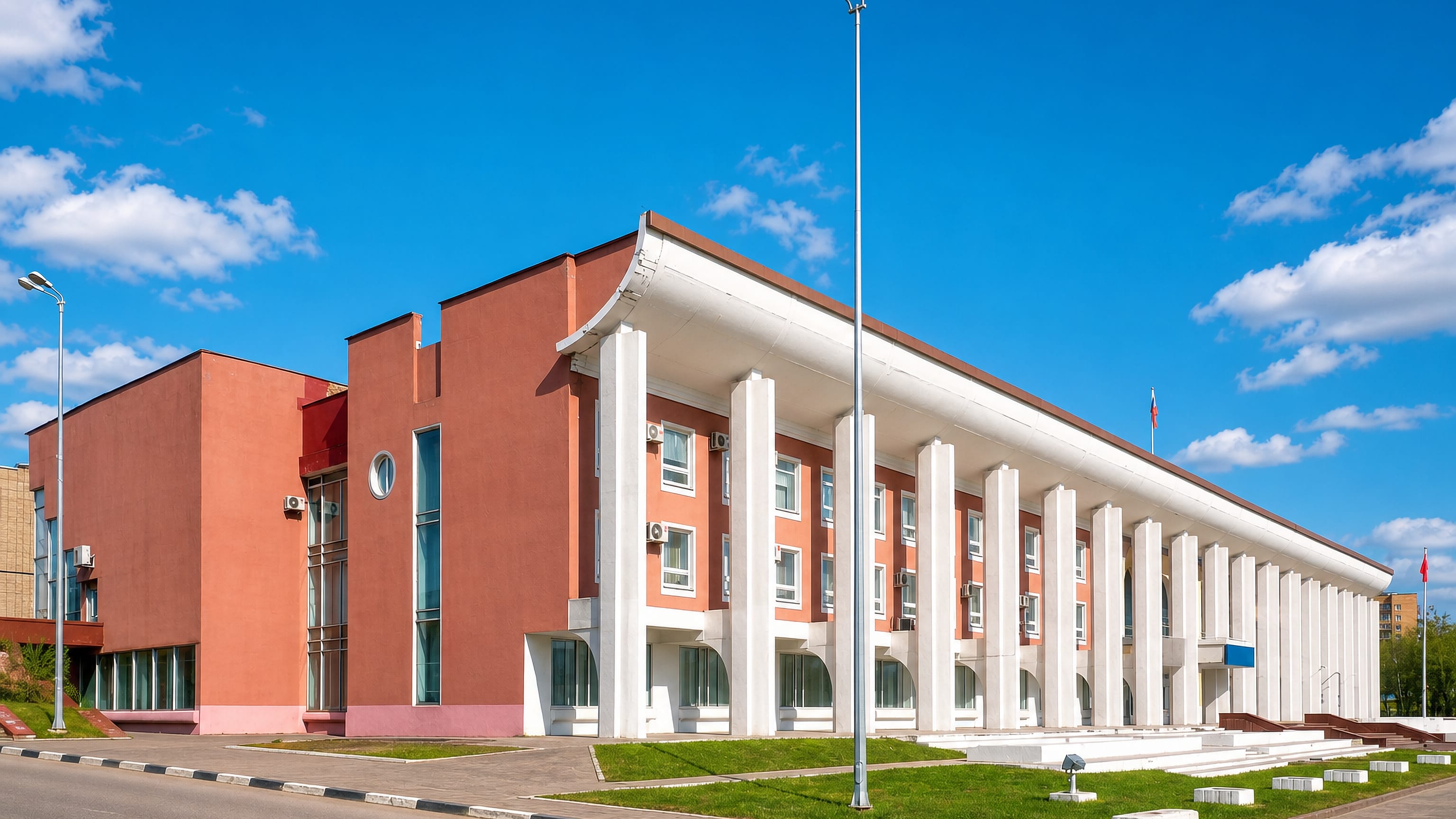 A Soviet-era house of culture with a white colonnade under a blue sky in Chekhov, Moscow Oblast