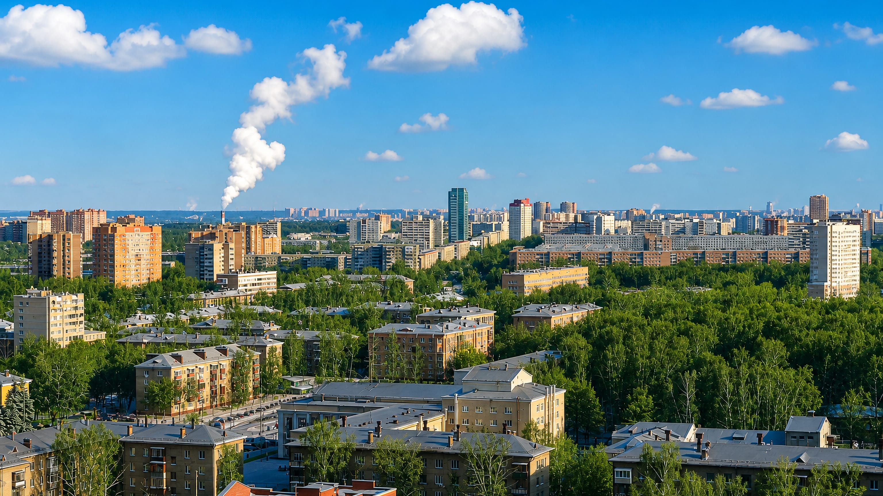 Leafy mid-rise apartment blocks and dense treetops across Korolev, Russia, under a clear summer sky