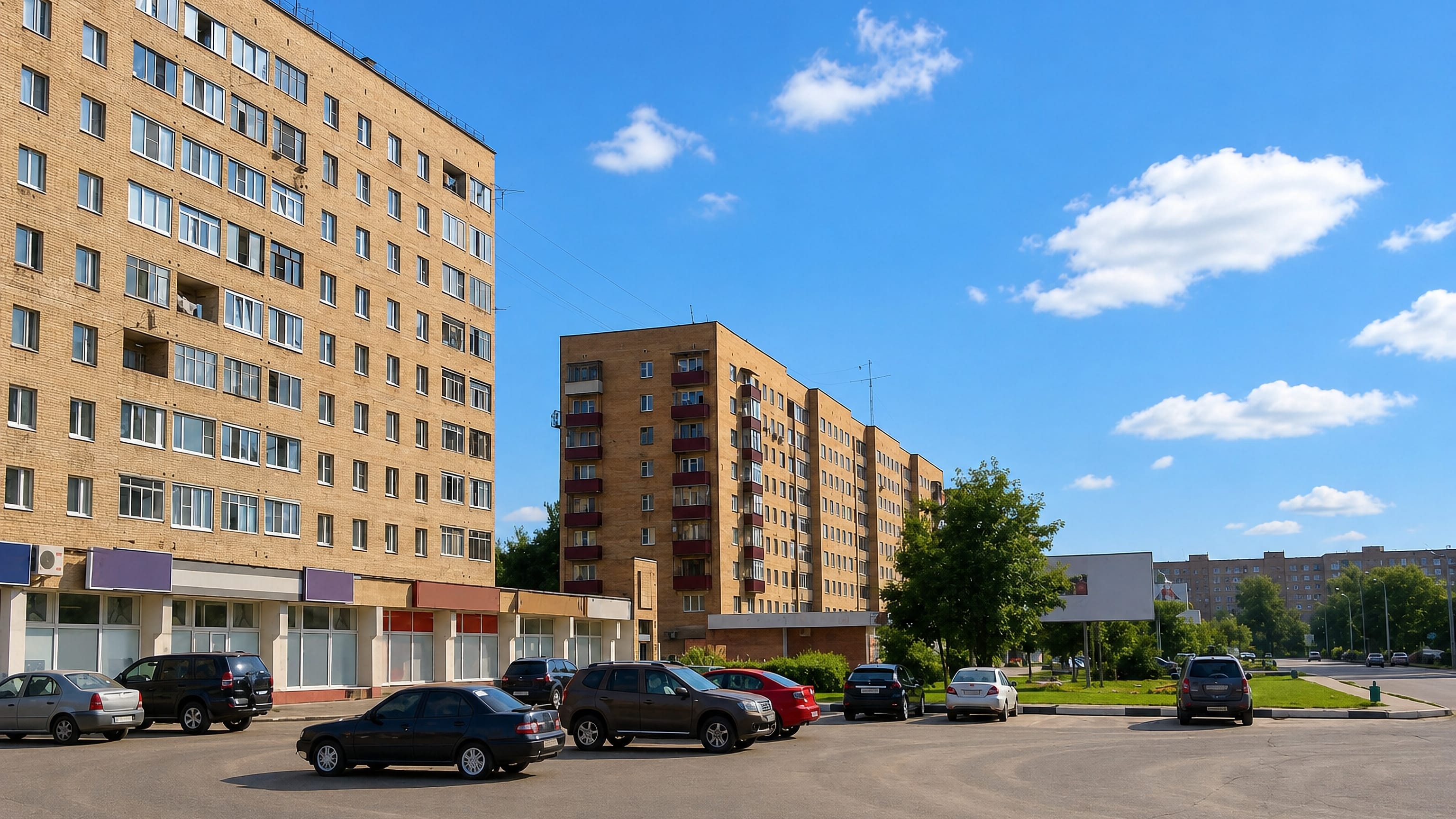 Soviet-era brick apartment blocks above a roadside parking area in Orekhovo-Zuyevo, Moscow region.