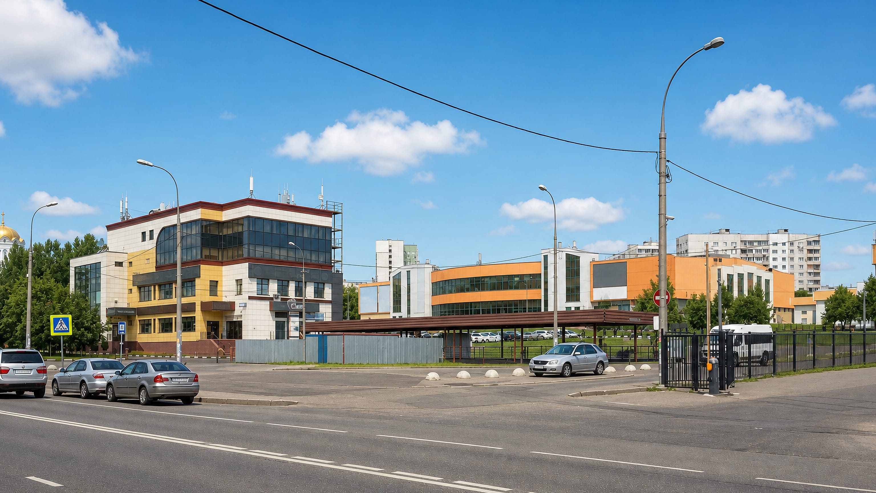 Wide daytime street in Moscow's Bibirevo district with panel apartment blocks and a modern office building.