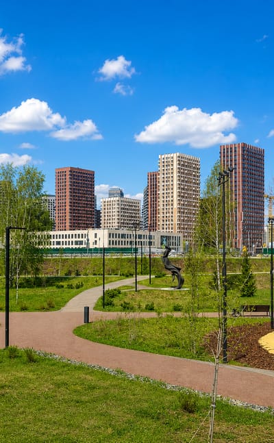 Landscaped park with winding paths and a playground below colourful modern high-rises in Pokrovskoye-Streshnevo, Moscow