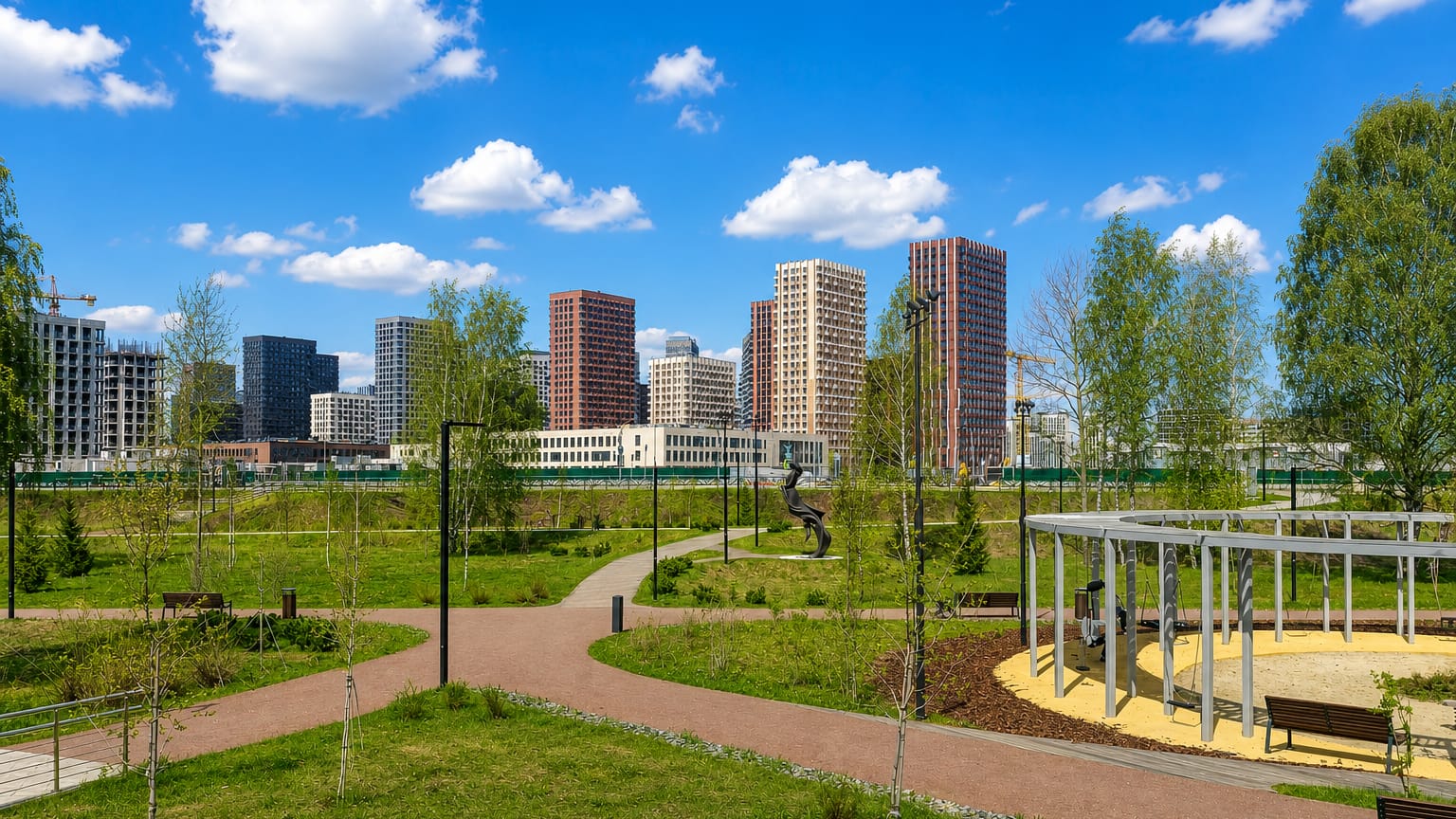 Landscaped park with winding paths and a playground below colourful modern high-rises in Pokrovskoye-Streshnevo, Moscow