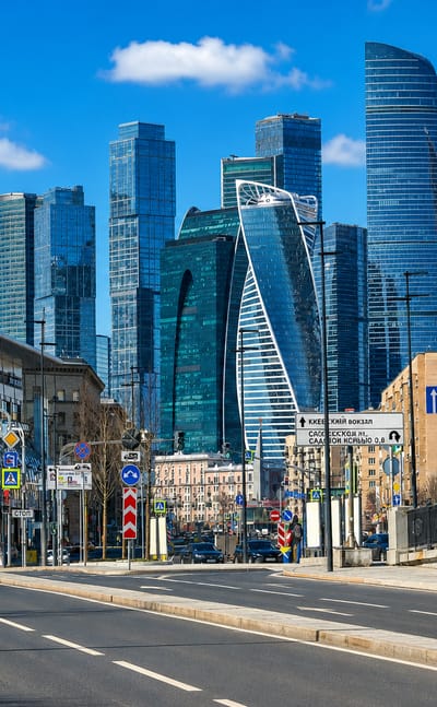 Street view toward the Moscow City skyscrapers of the Presnensky district under a clear blue sky.