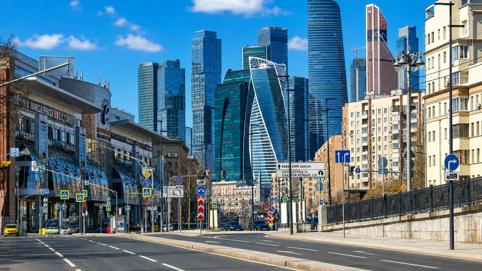 Street view toward the Moscow City skyscrapers of the Presnensky district under a clear blue sky.