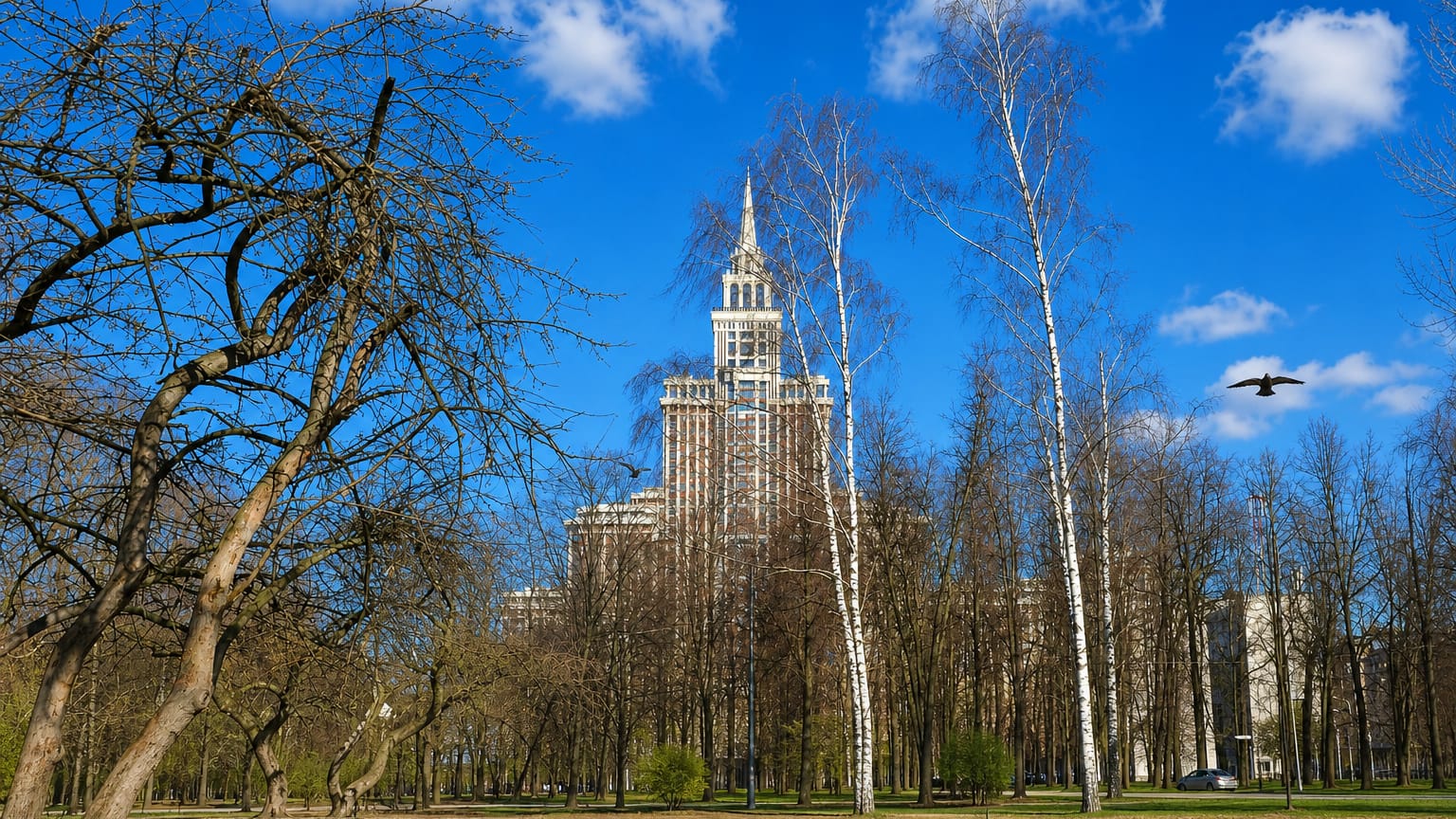 Stalin-era spired skyscraper rising above a pond and birch trees in the Sokol district of Moscow