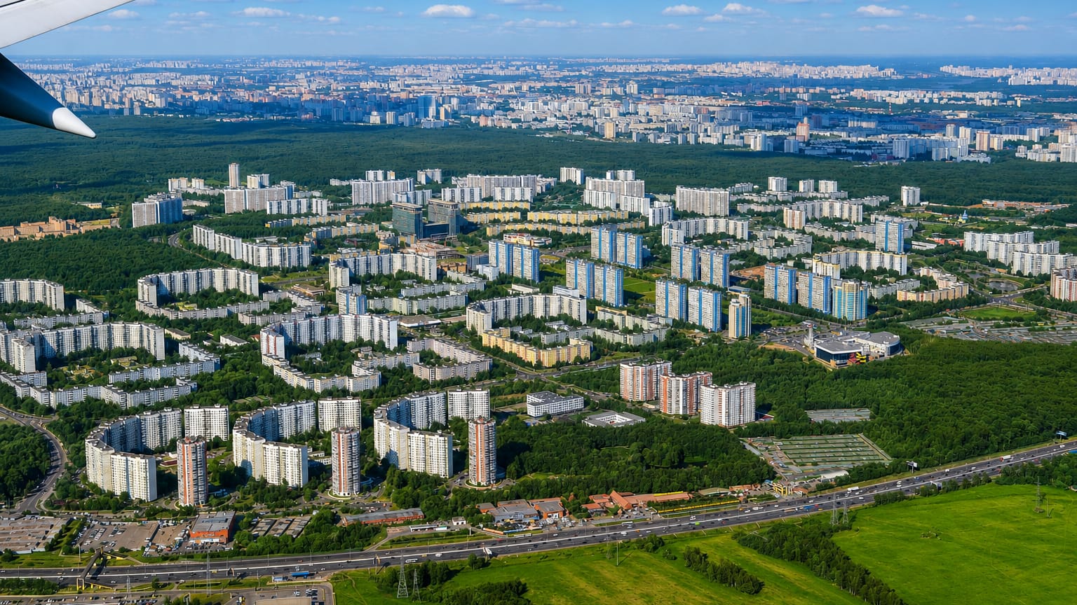 Aerial view of Yasenevo's Soviet-era apartment blocks bordered by dense forest on Moscow's southern edge.