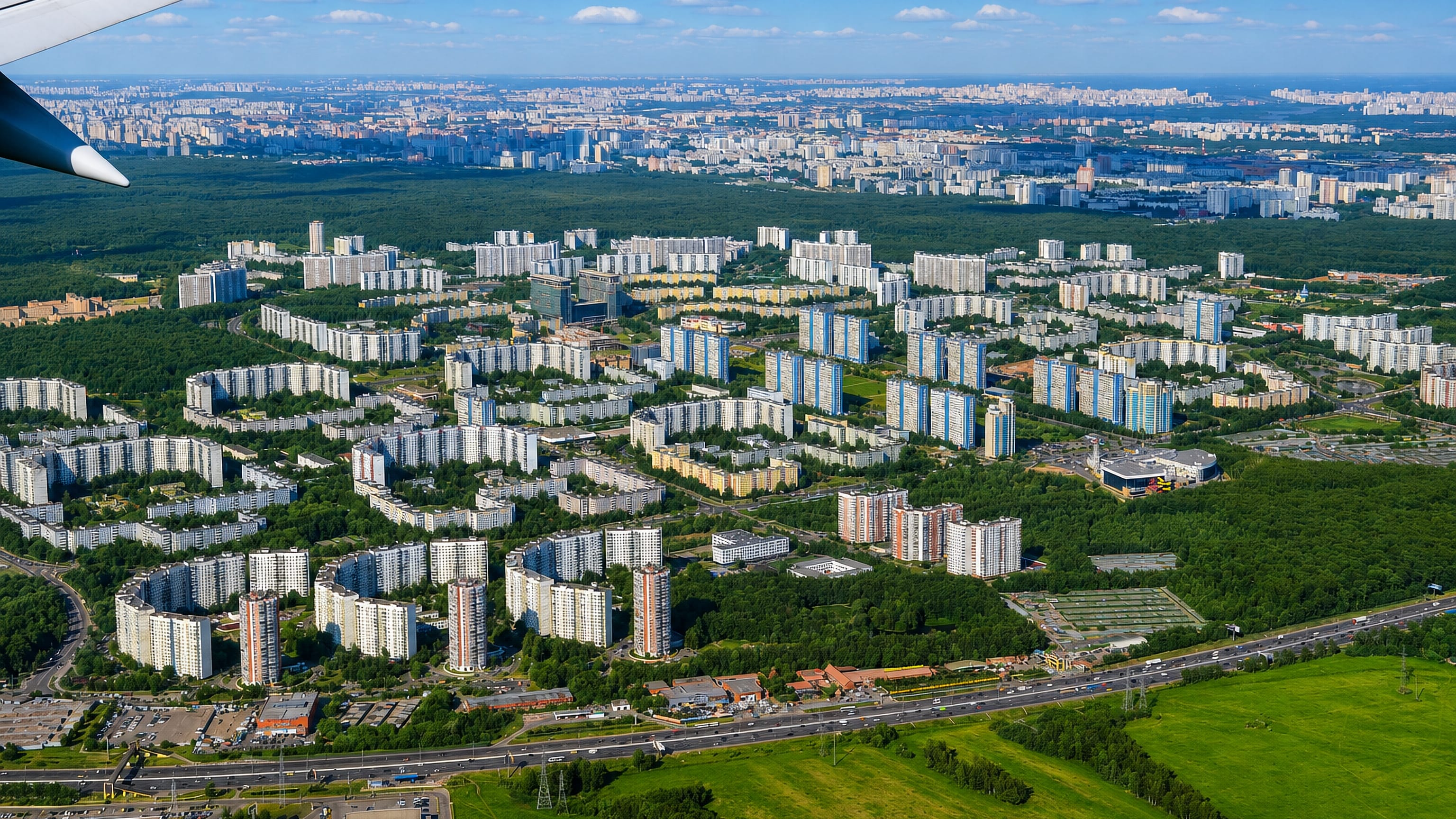 Aerial view of Yasenevo's Soviet-era apartment blocks bordered by dense forest on Moscow's southern edge.