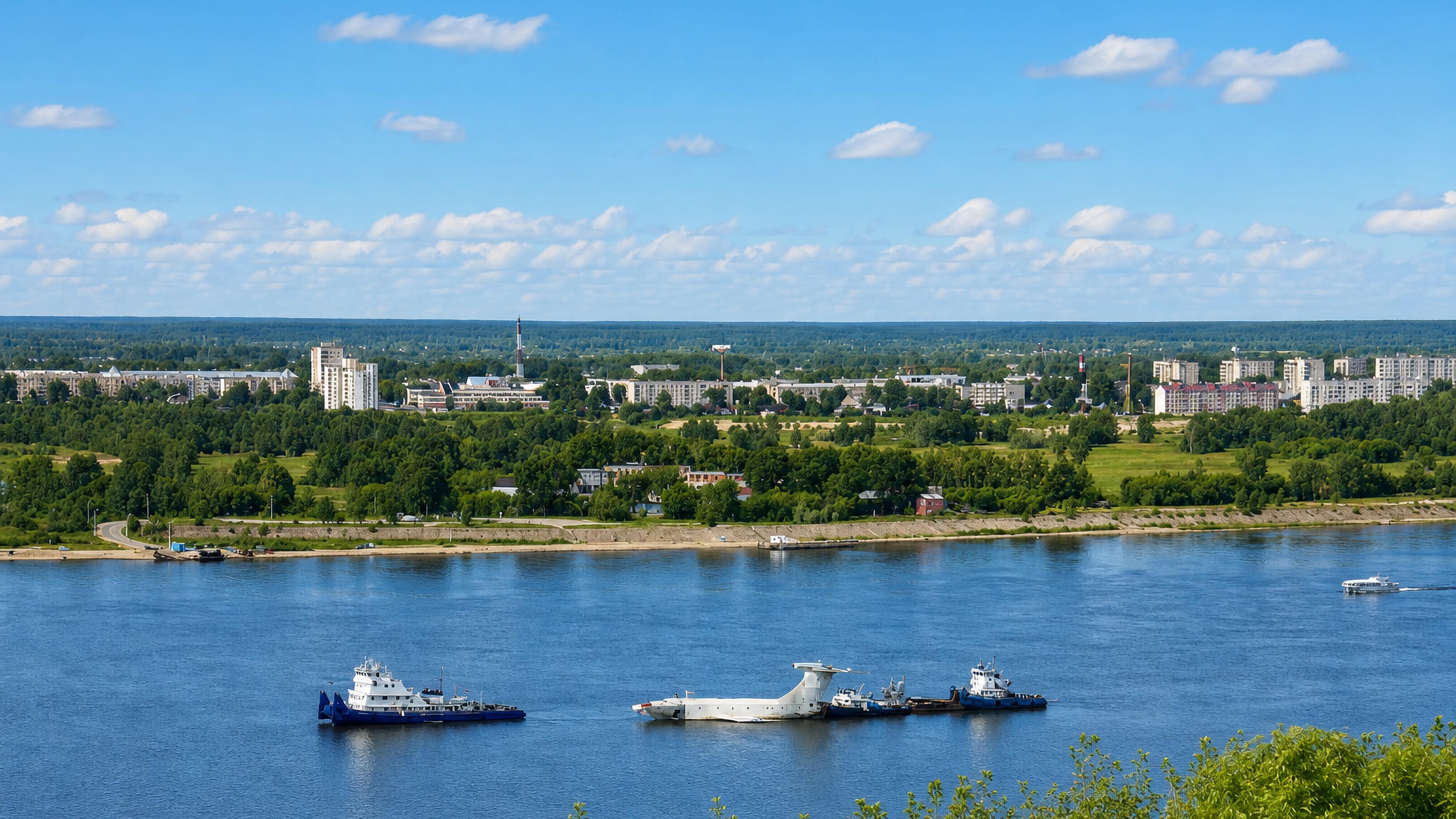 Bor's low-rise waterfront seen across the Volga, with barges and tugs working the river.