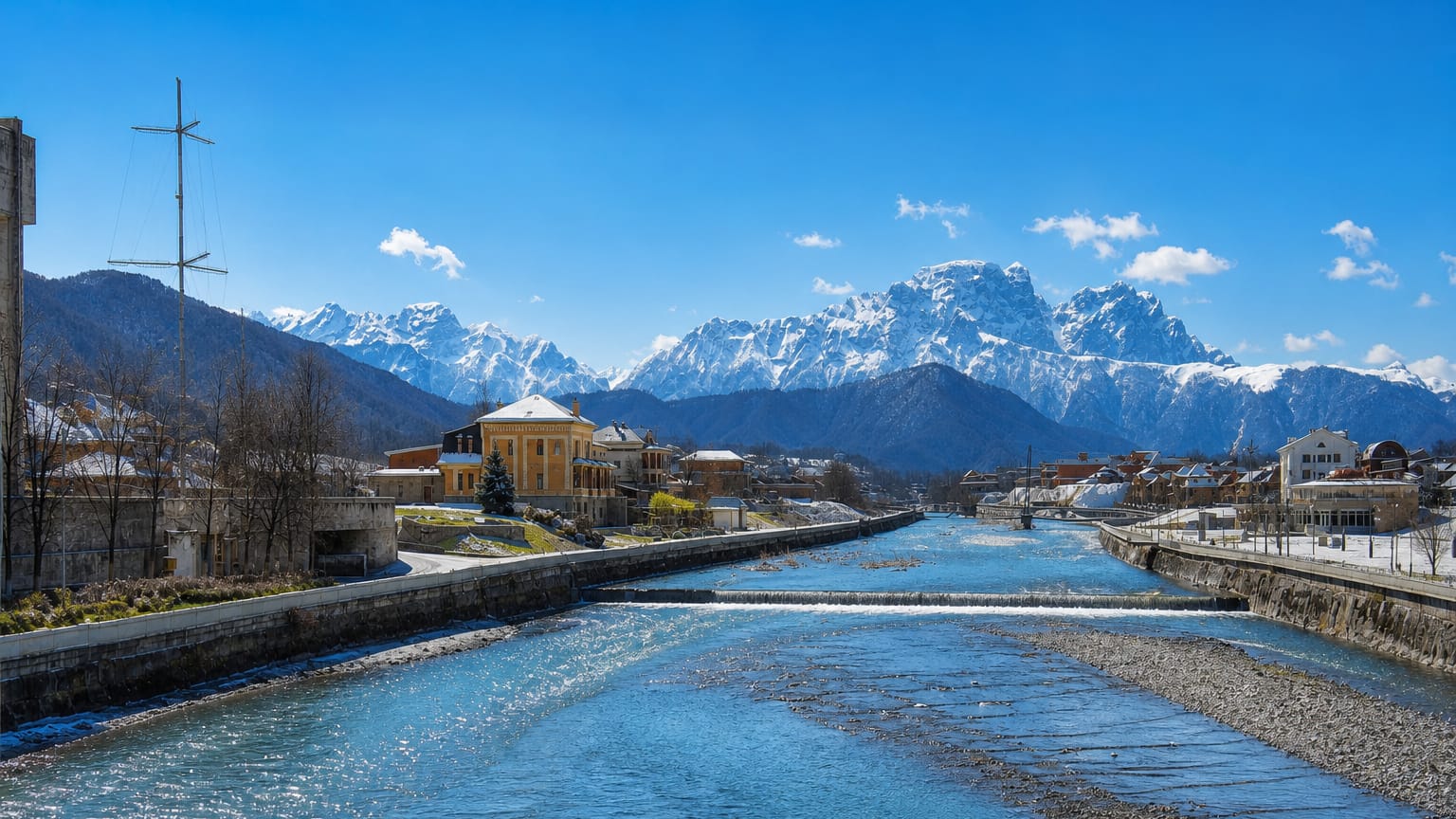 River flowing through a snow-capped mountain town representing Vladikavkaz, Russia