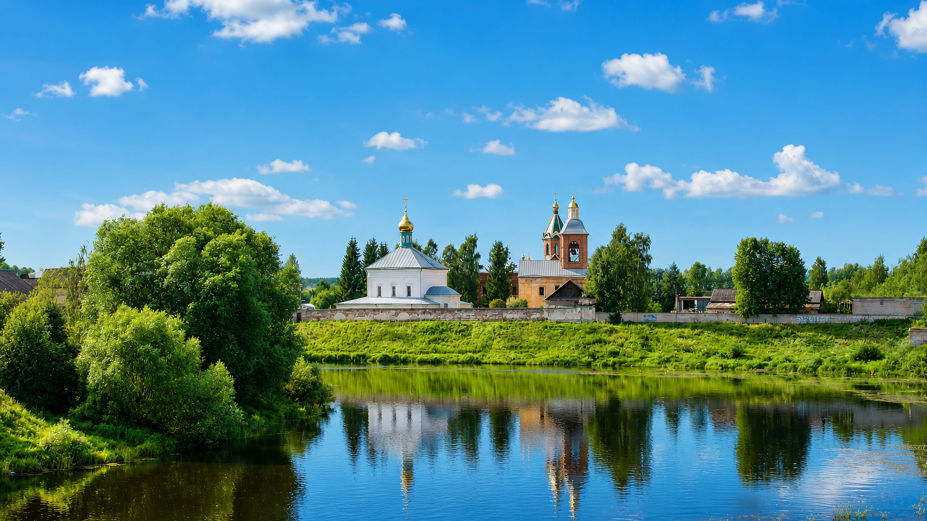 A white Orthodox church with gilded domes above the river bank at Borovichi, Novgorod Oblast, Russia