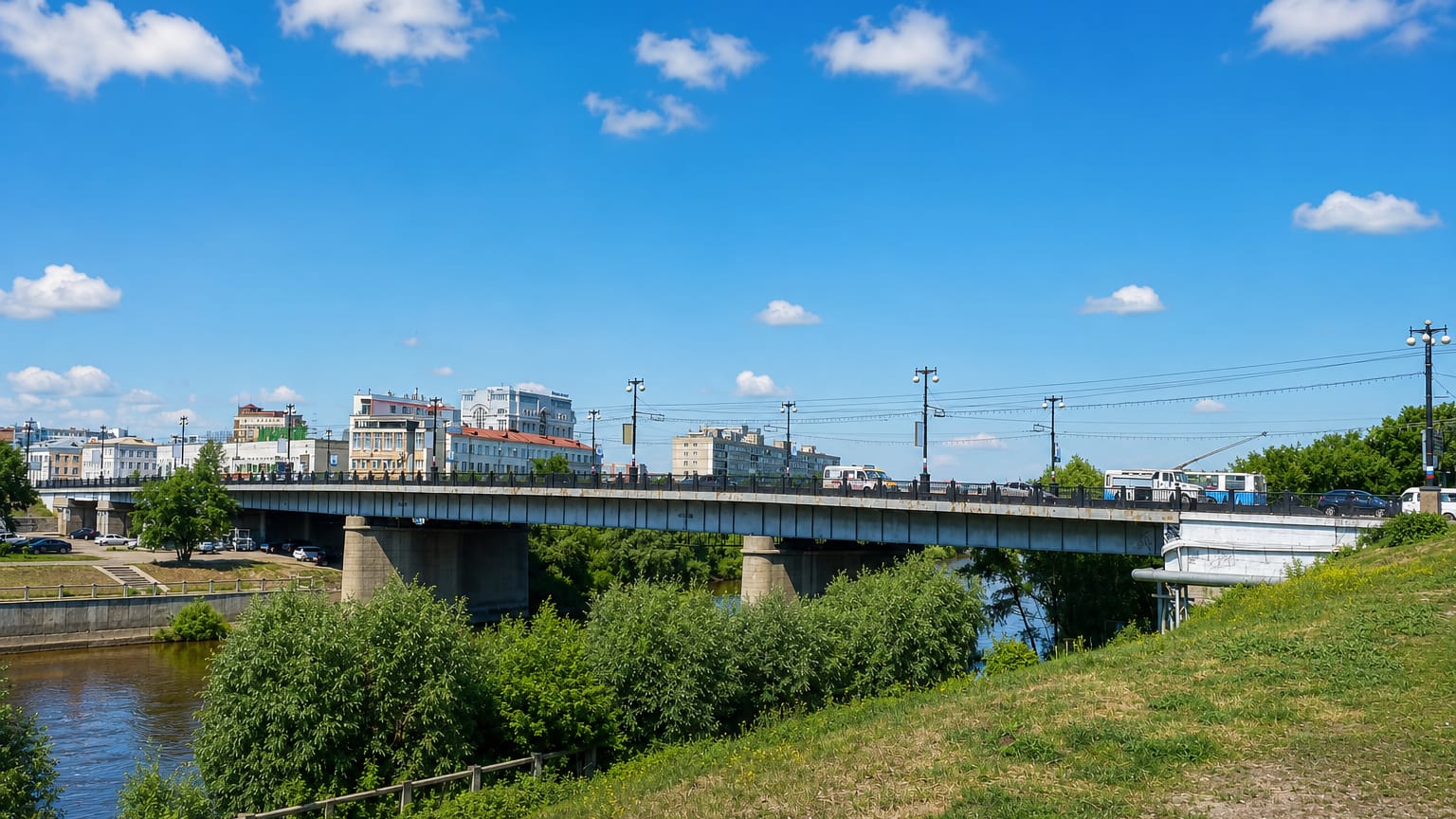 Road bridge carrying traffic over the Om River with Omsk's riverfront buildings behind.