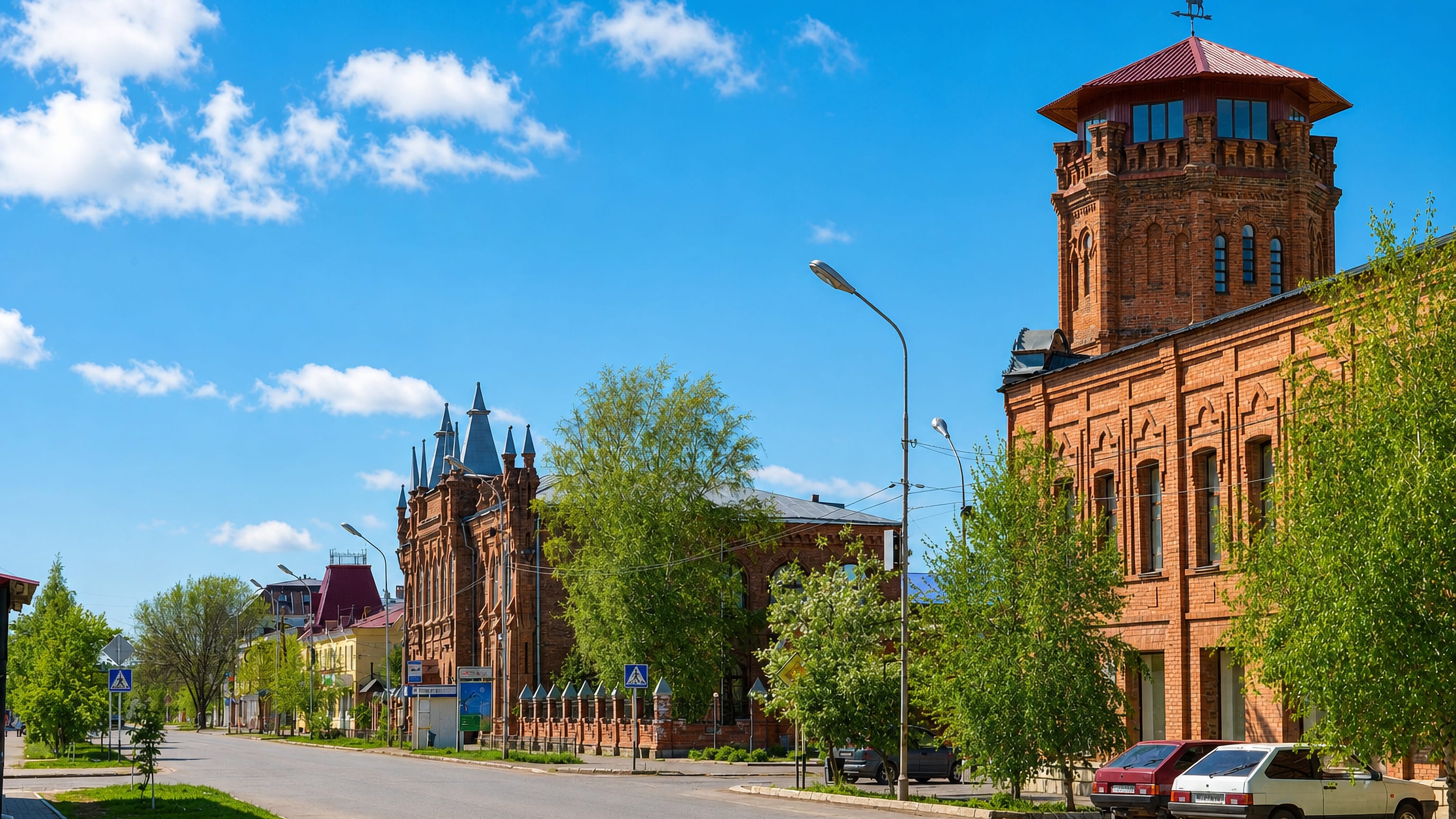 Red-brick merchant houses and a corner tower along a quiet central street in Buzuluk, Russia
