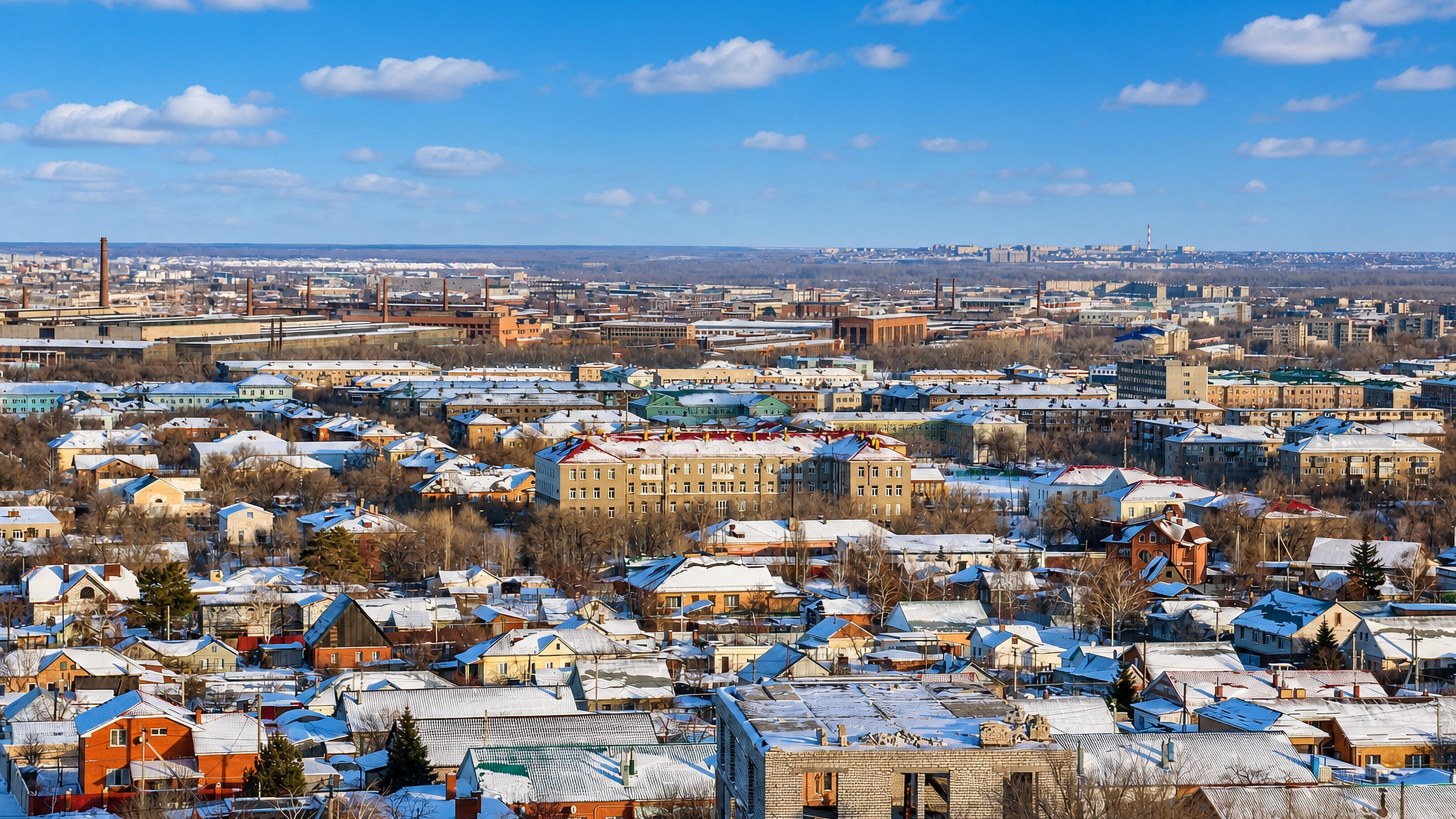 Snow-covered rooftops and industrial chimneys spreading across Orsk in Russia's Orenburg Oblast