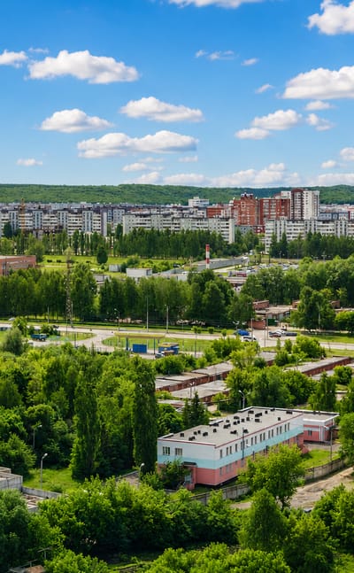 Aerial view of Penza's residential districts and greenery under a partly cloudy sky