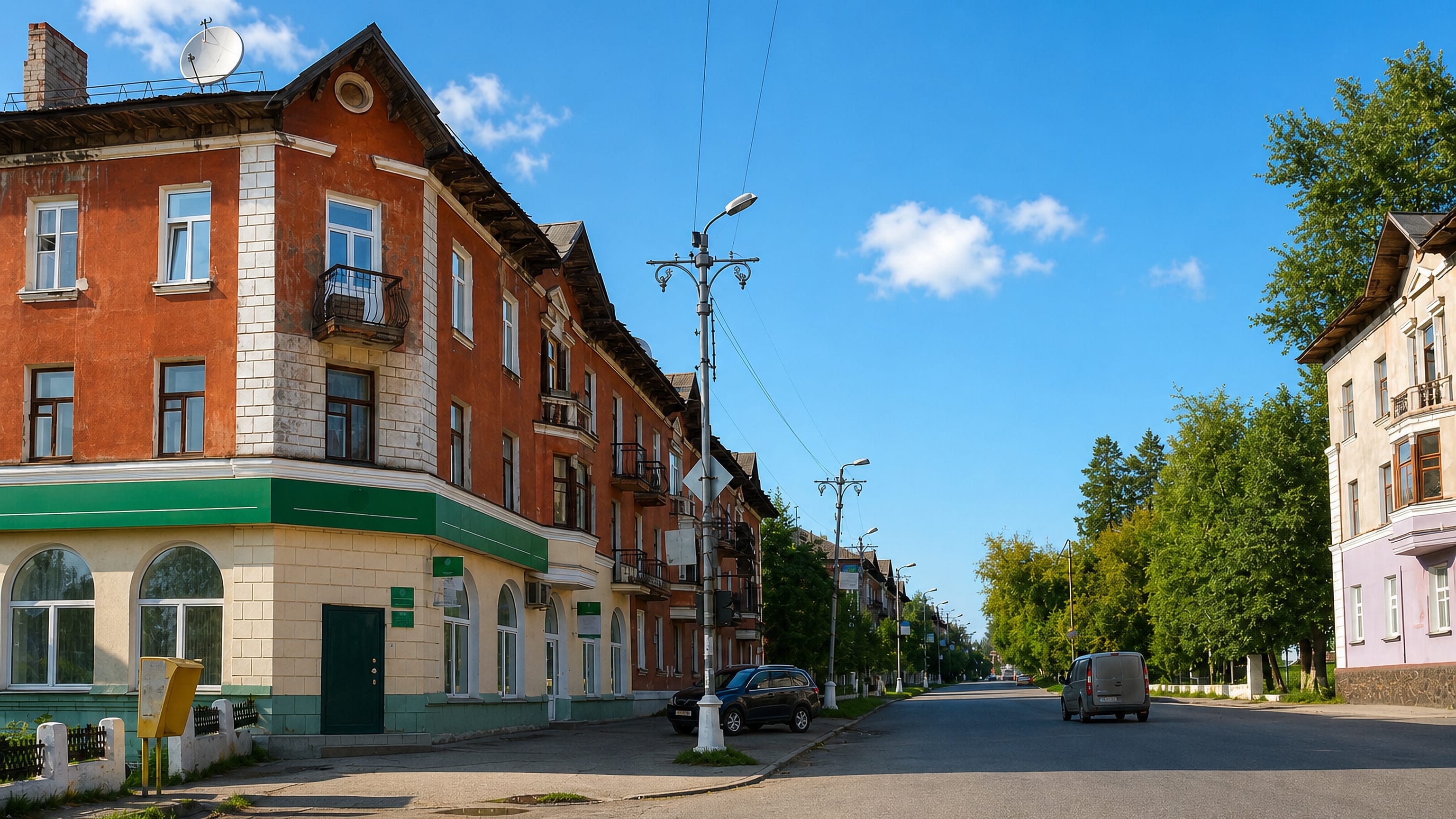 Sunlit Stalin-era apartment blocks lining a quiet main street in Chusovoy, Perm Krai.
