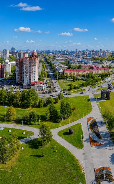 Aerial of a landscaped park, boulevards and apartment towers with the Kama River beyond in Perm, Russia