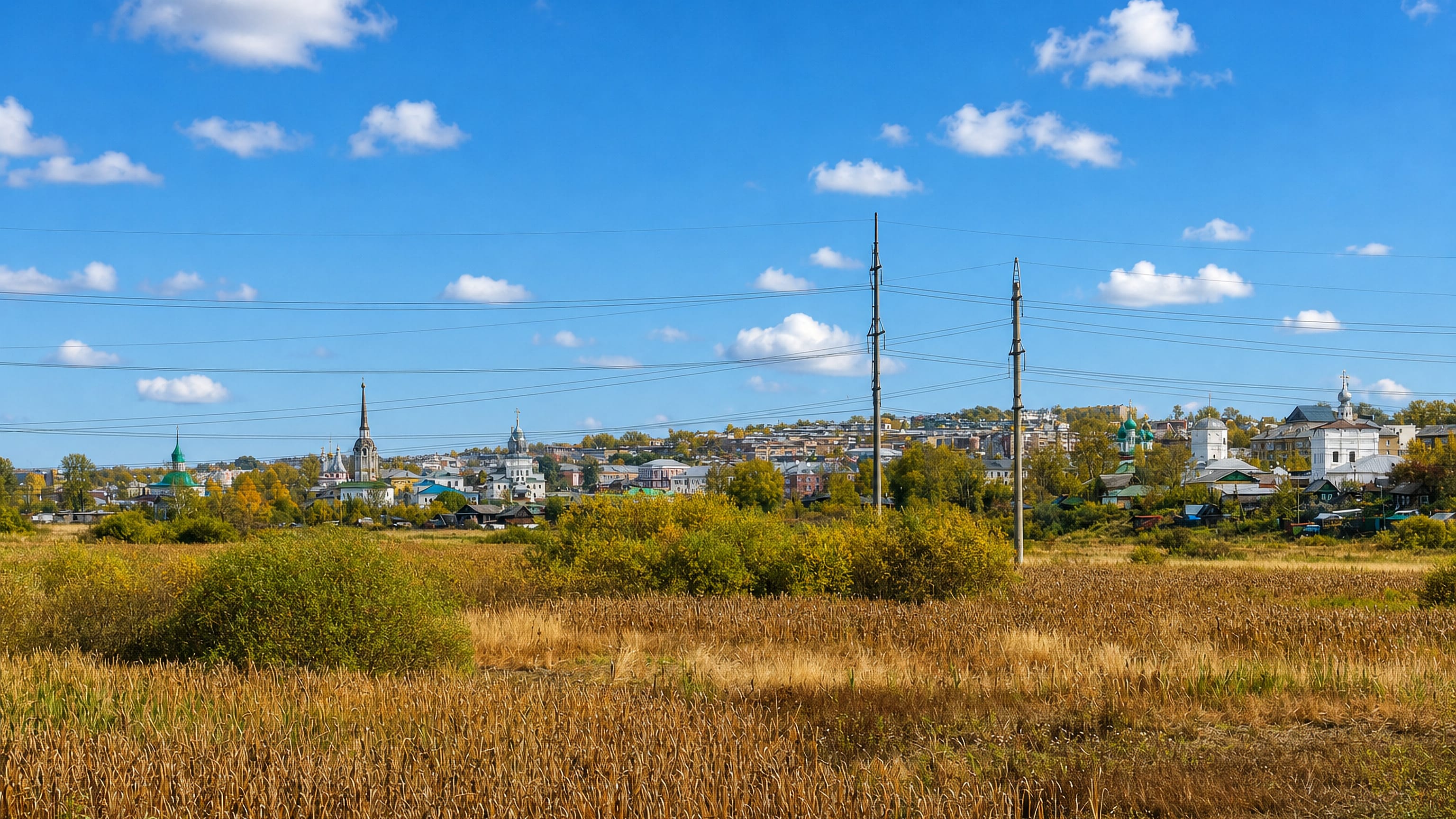Solikamsk, Russia, seen across autumn fields, its white churches and green domes standing on the skyline.
