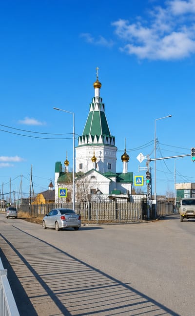 Street in Markha, Yakutsk, with a green-roofed white Orthodox church and wide roadway