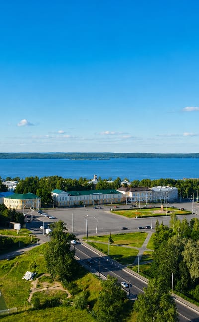 Aerial view of Petrozavodsk with a columned building and Lake Onega stretching to the horizon.