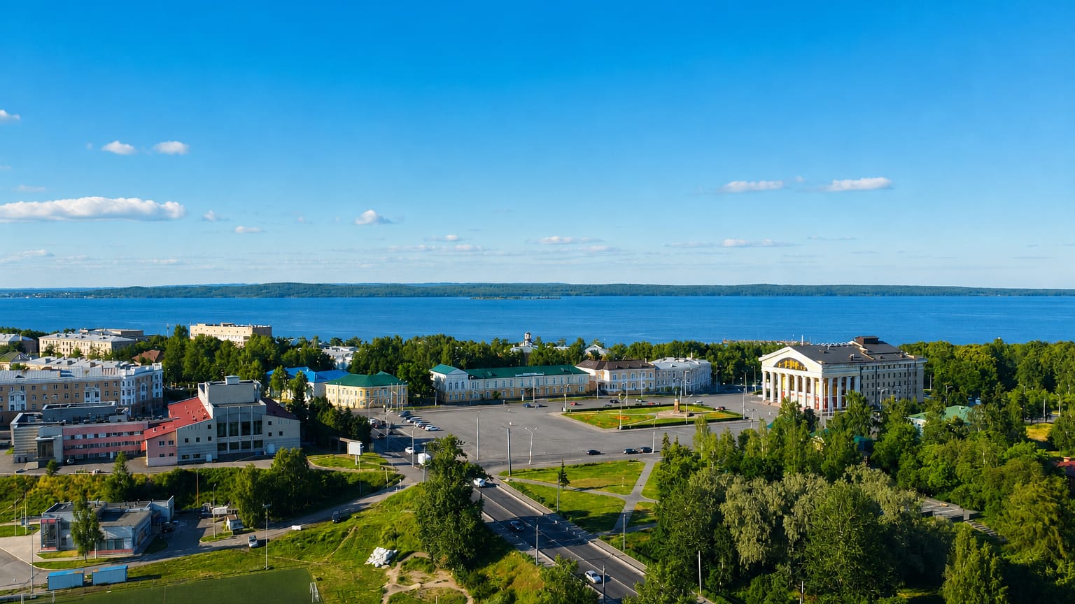 Aerial view of Petrozavodsk with a columned building and Lake Onega stretching to the horizon.