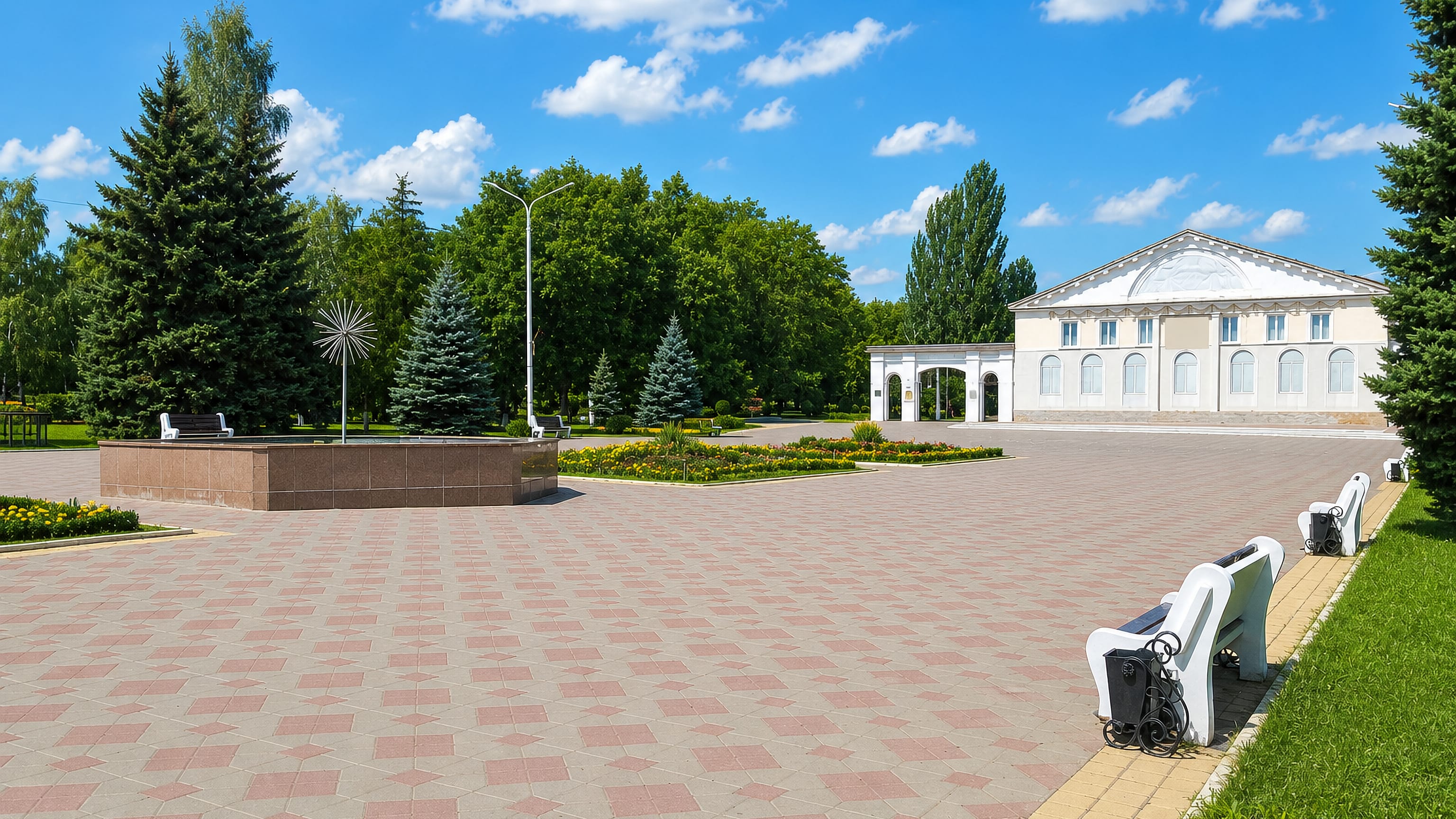 Paved central square with a neoclassical house of culture, spruces and flowerbeds in Donetsk, Rostov Oblast.