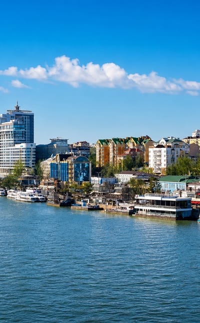 Rostov-on-Don Don River embankment with moored river boats, a golden-domed cathedral and mid-rise buildings