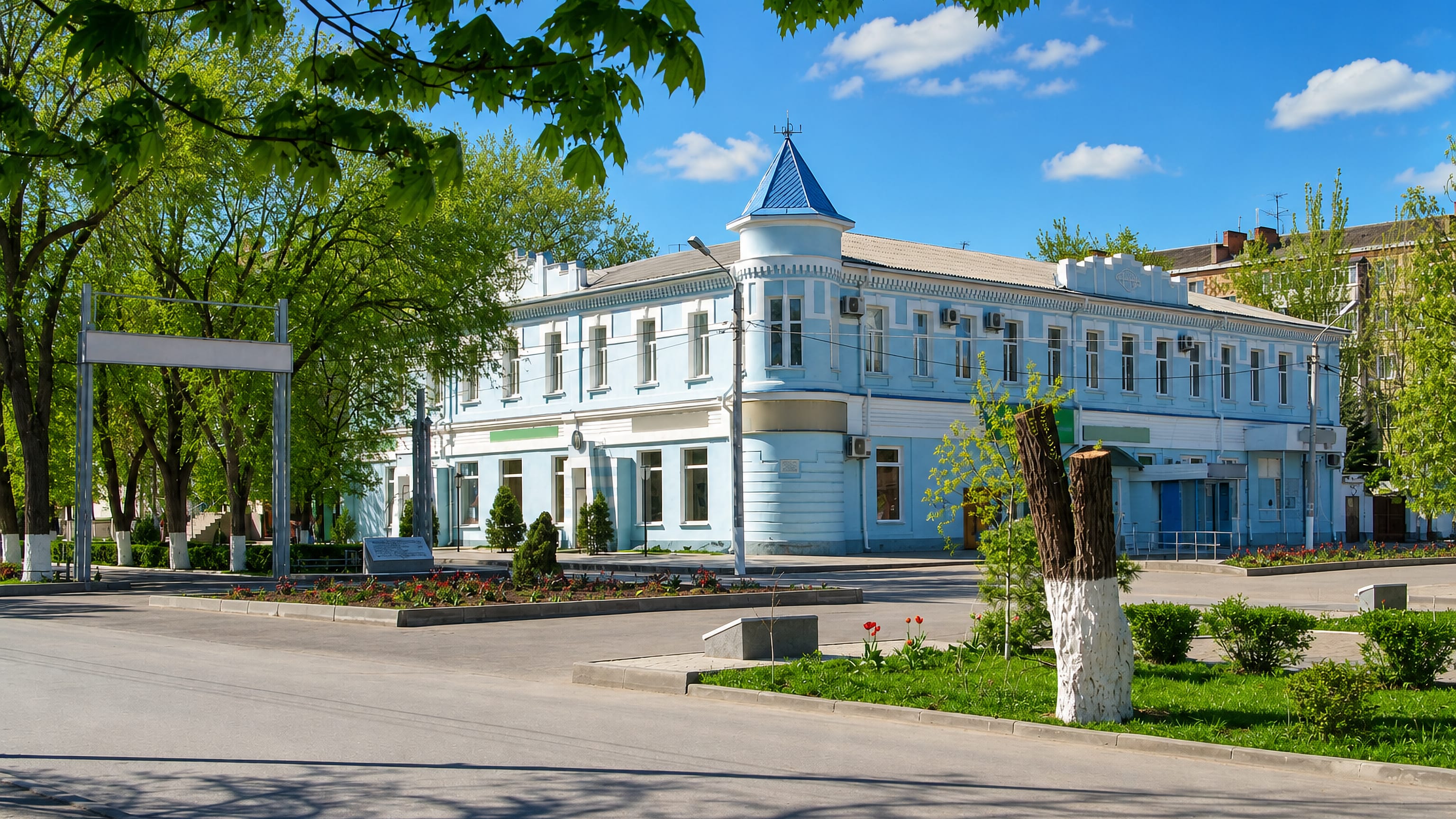 Pale blue two-storey historic building on a tree-lined central street in Sal'sk, Rostov Oblast