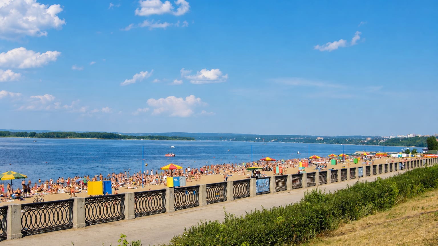 Samara's Volga River embankment and its crowded city beach on a bright summer day.