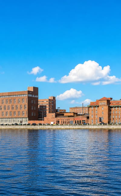 Red-brick industrial buildings and chimneys along the waterfront of Sampsonievskiy, St Petersburg.