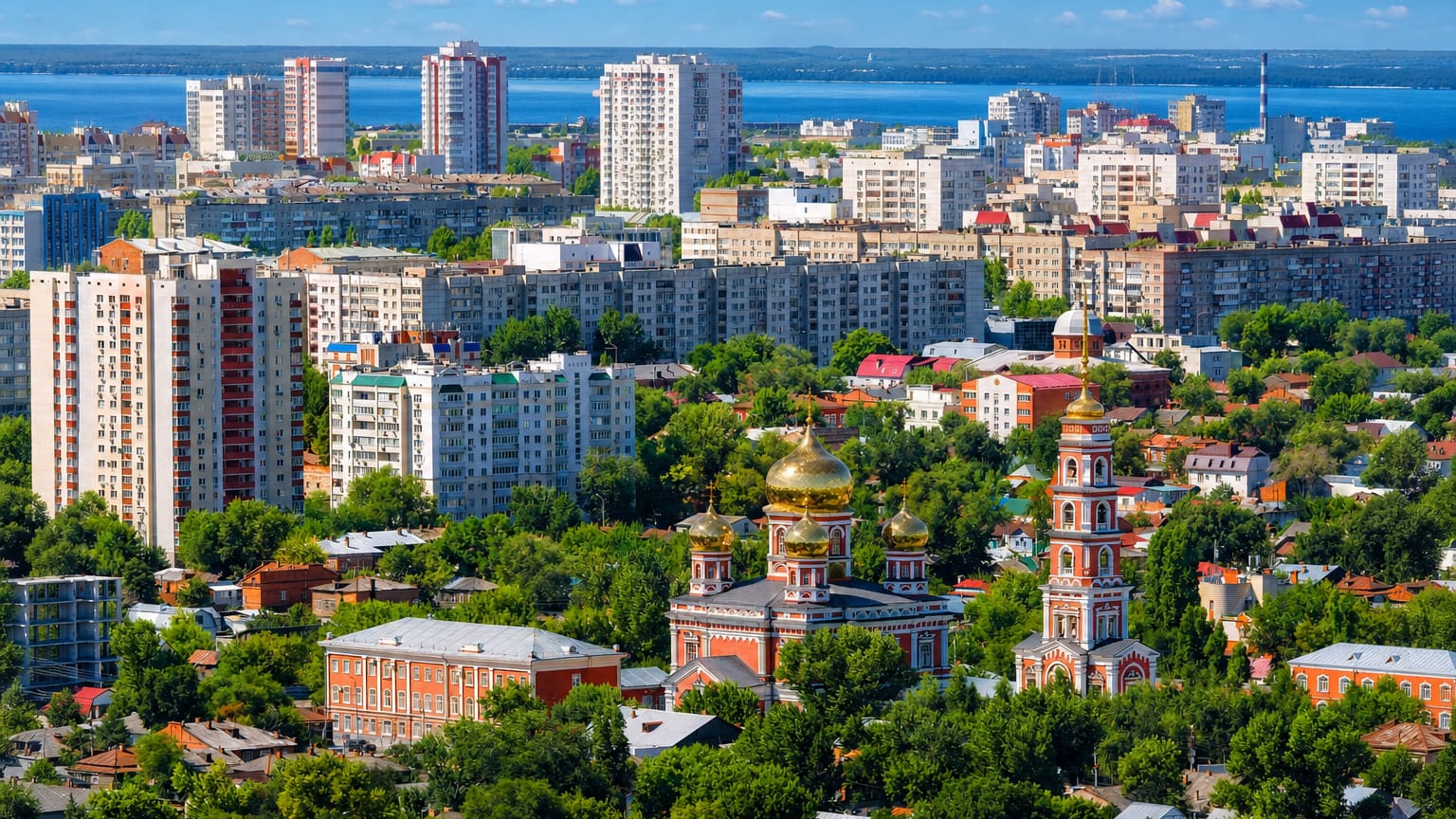 Aerial view of Saratov with a golden-domed Orthodox church, apartment blocks and the Volga River beyond.