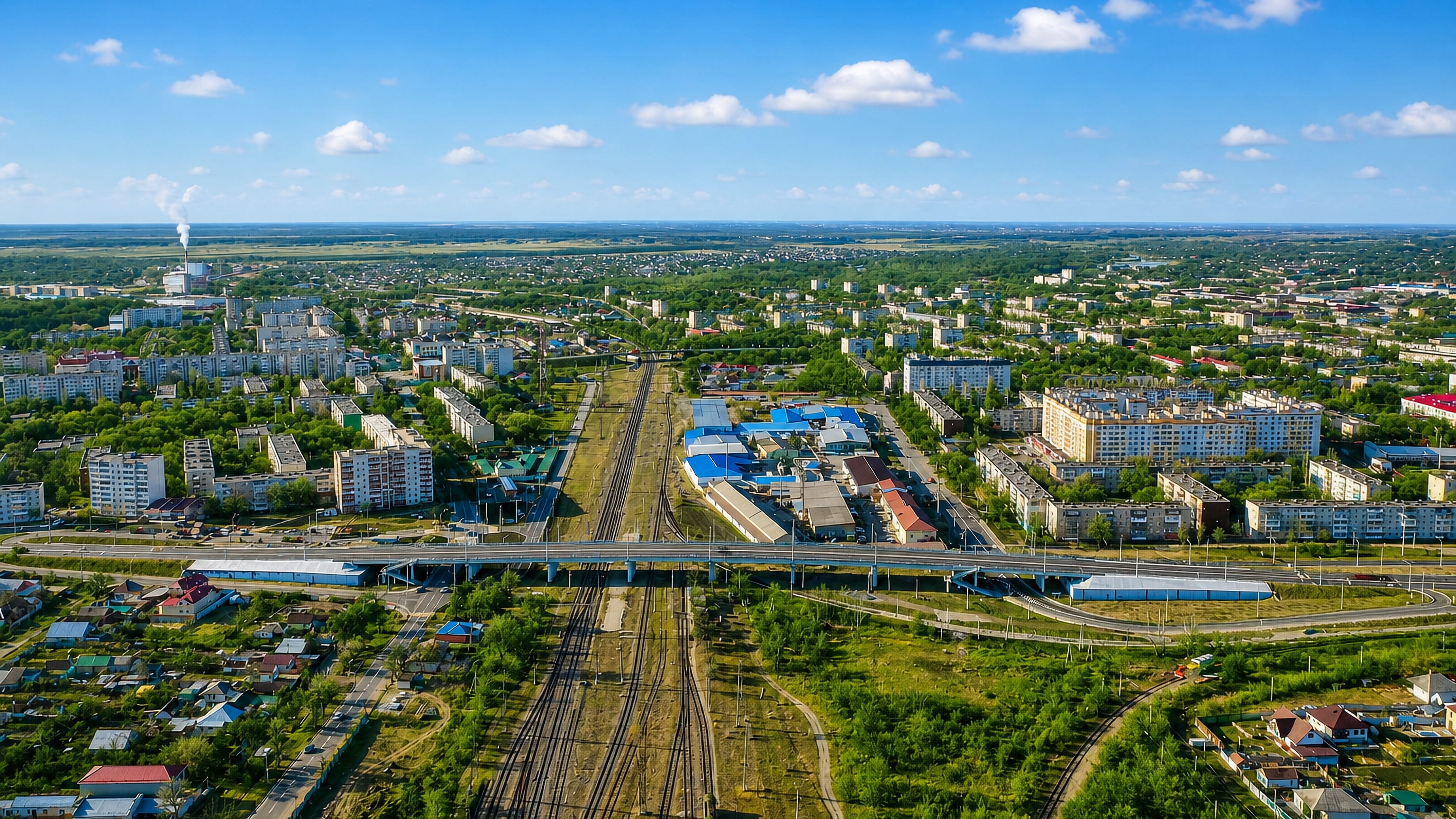 Aerial view of Nevinnomyssk, Russia, with railway yards, a road overpass and Soviet-era apartment blocks.