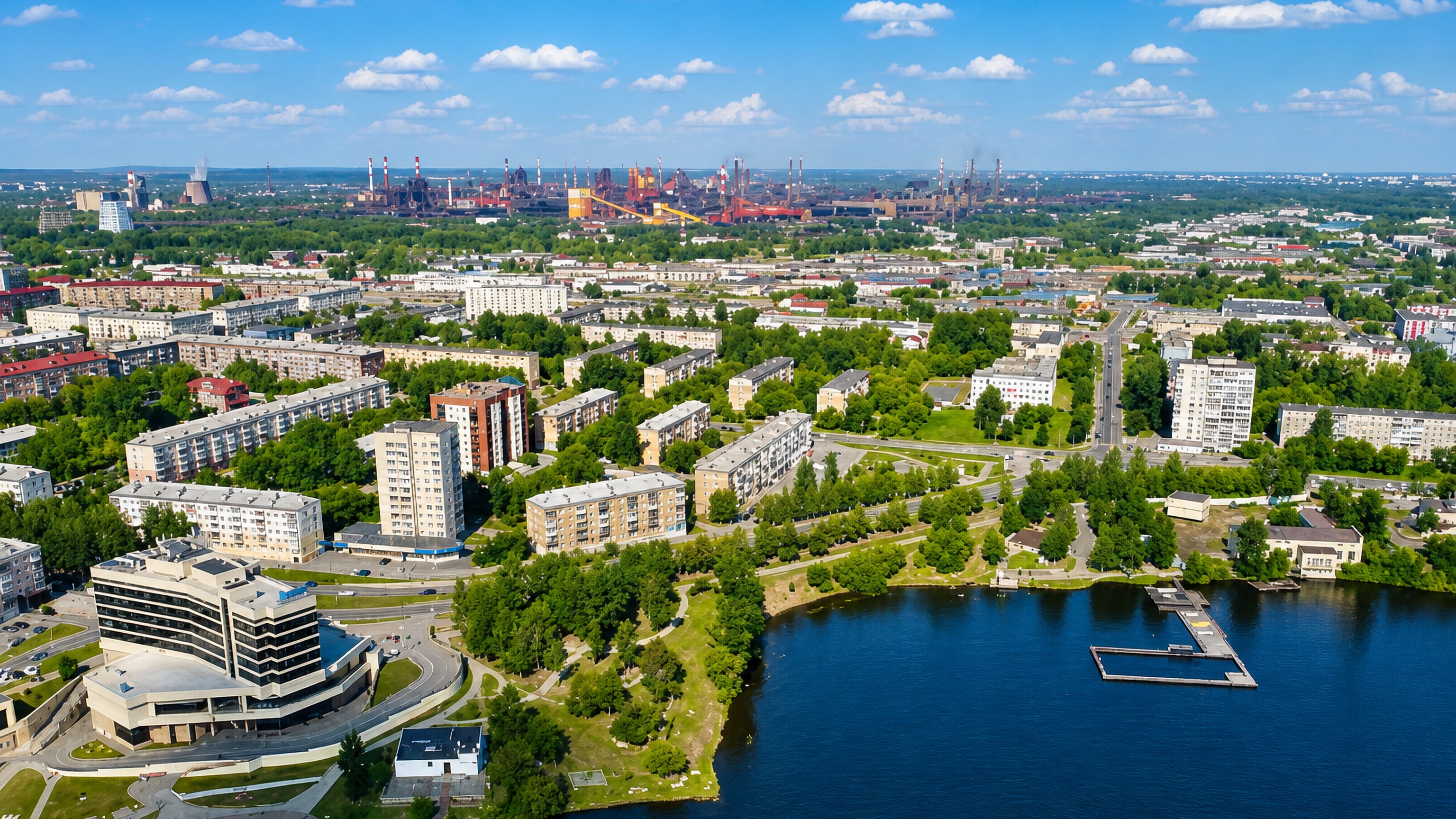 Aerial view of Nizhny Tagil across its pond, with Soviet-era apartment blocks and the metallurgical plant beyond.