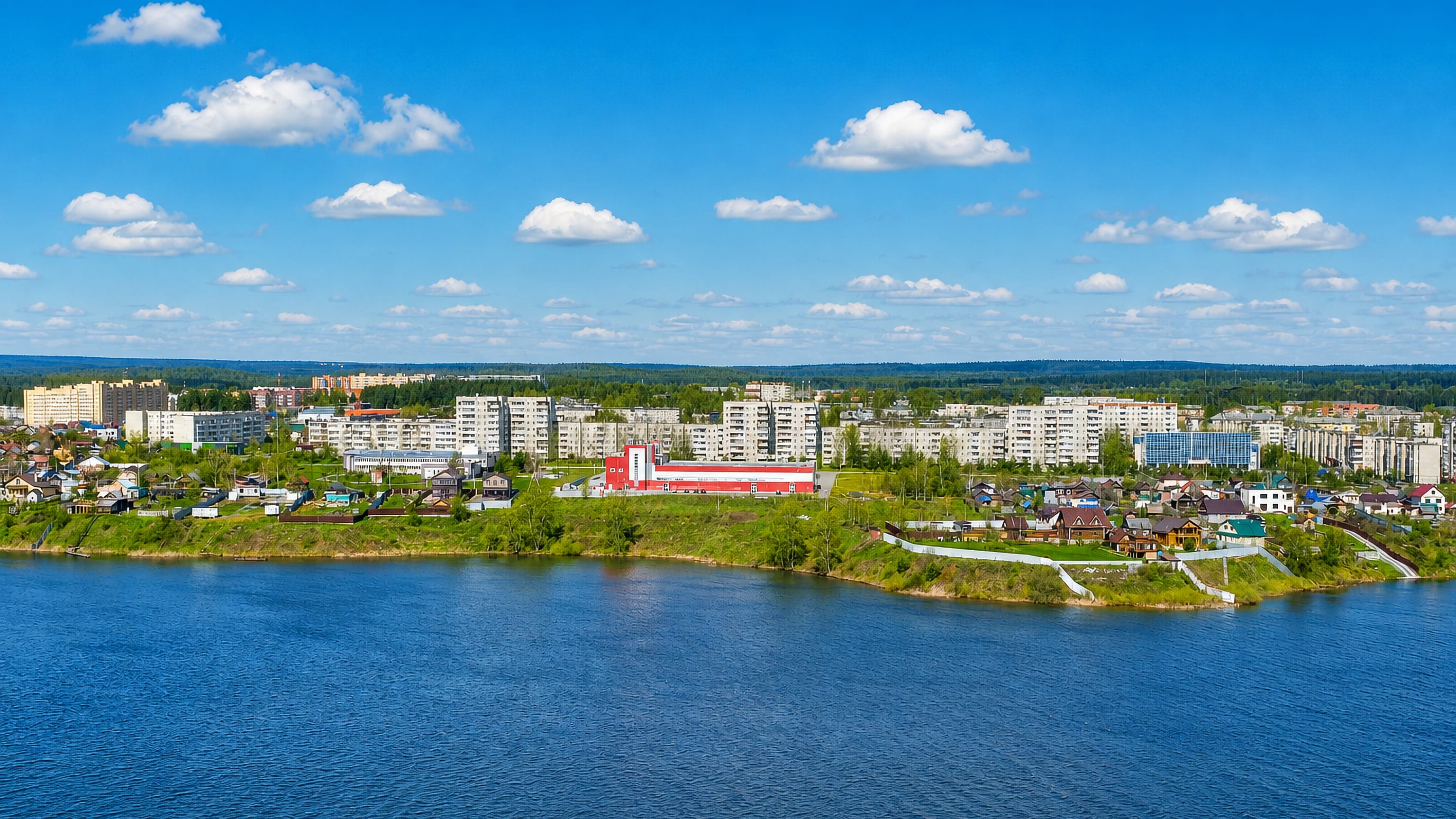 Revda's apartment blocks and lakeside houses seen across the town pond, Sverdlovsk Oblast, Russia.