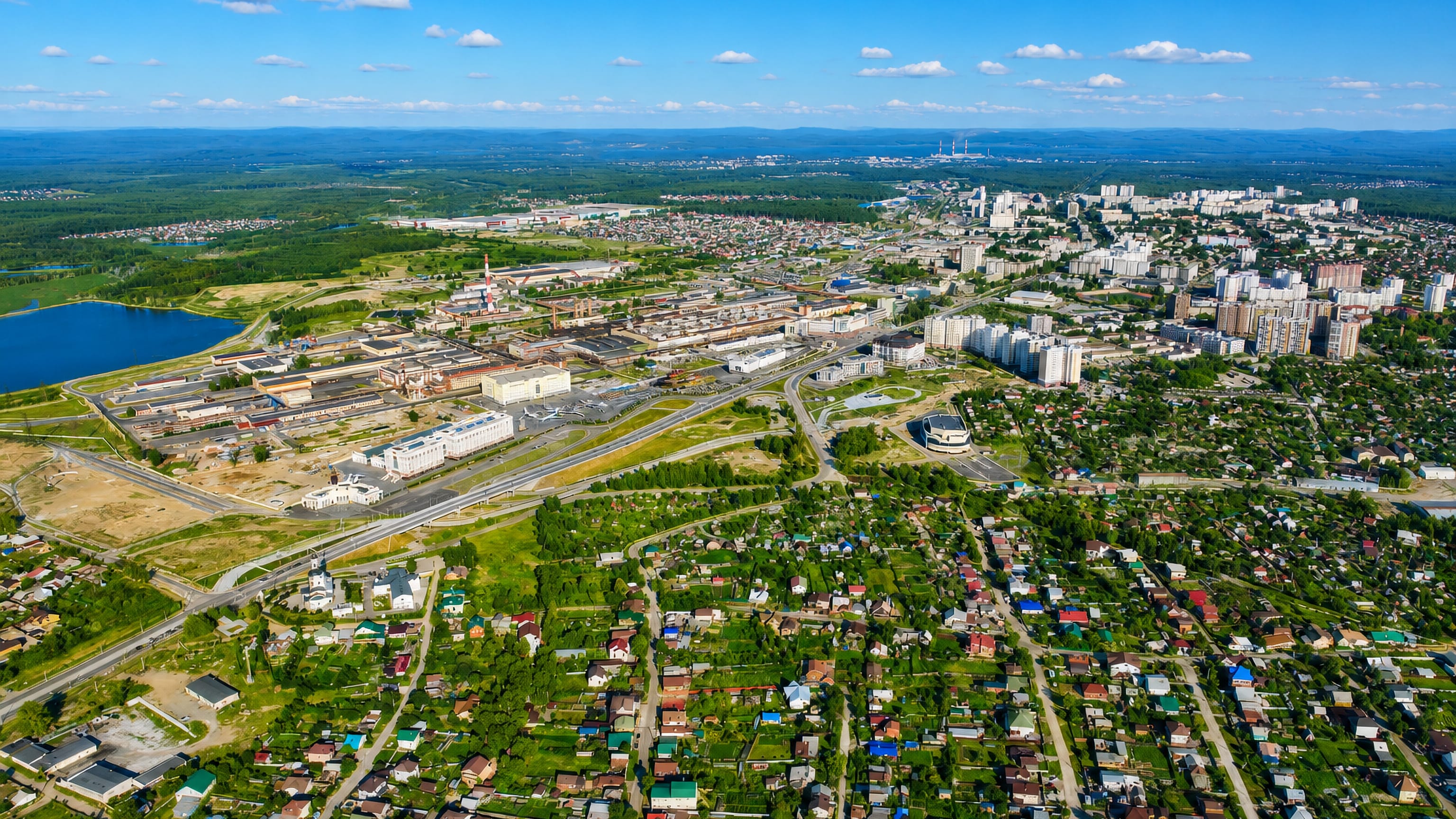 Aerial view of Verkhnyaya Pyshma, Russia, with its industrial works, apartment blocks and forested lakes.