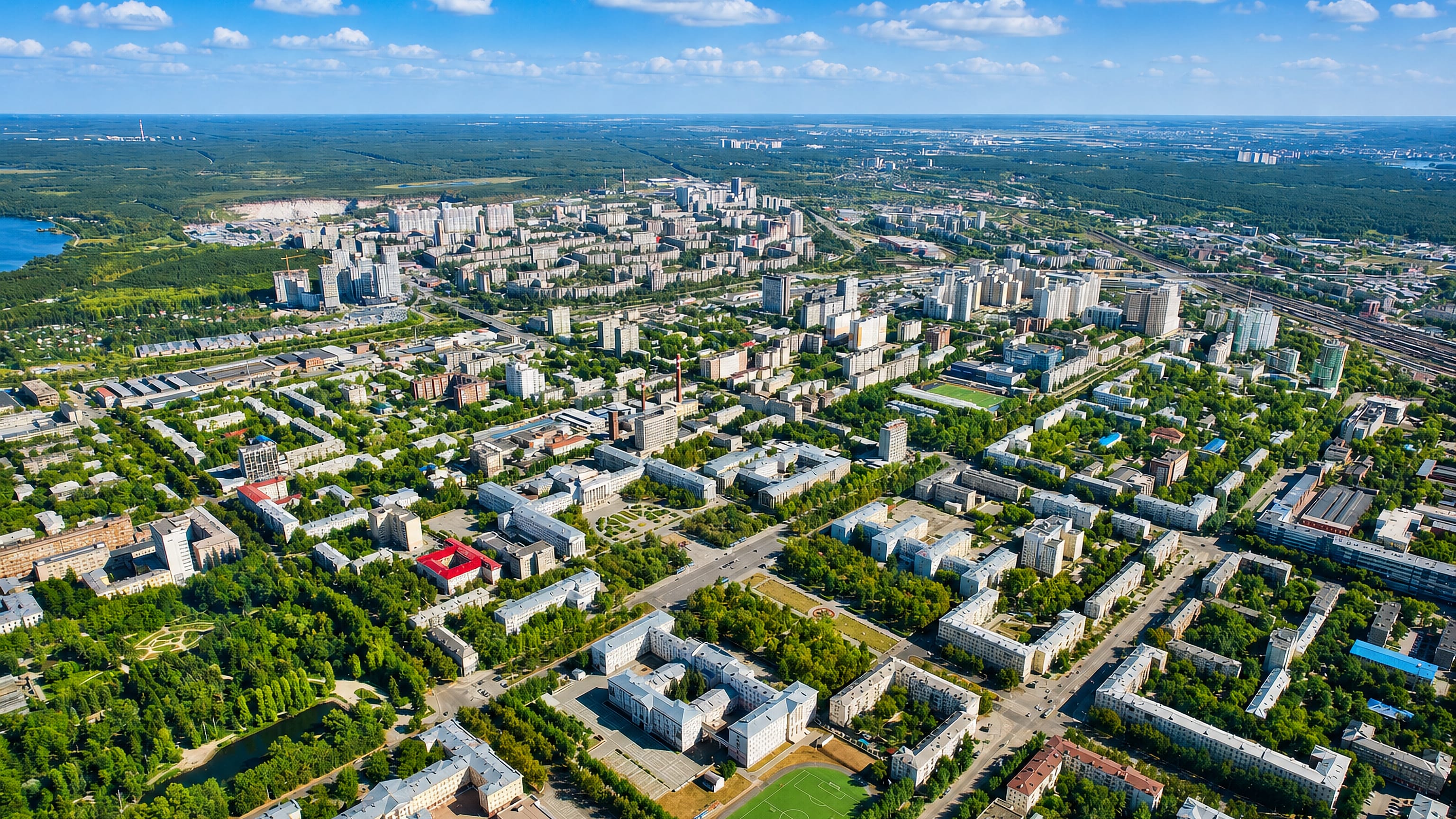 Aerial view of apartment blocks, sports grounds and forest edging Kirovsky District, Yekaterinburg.