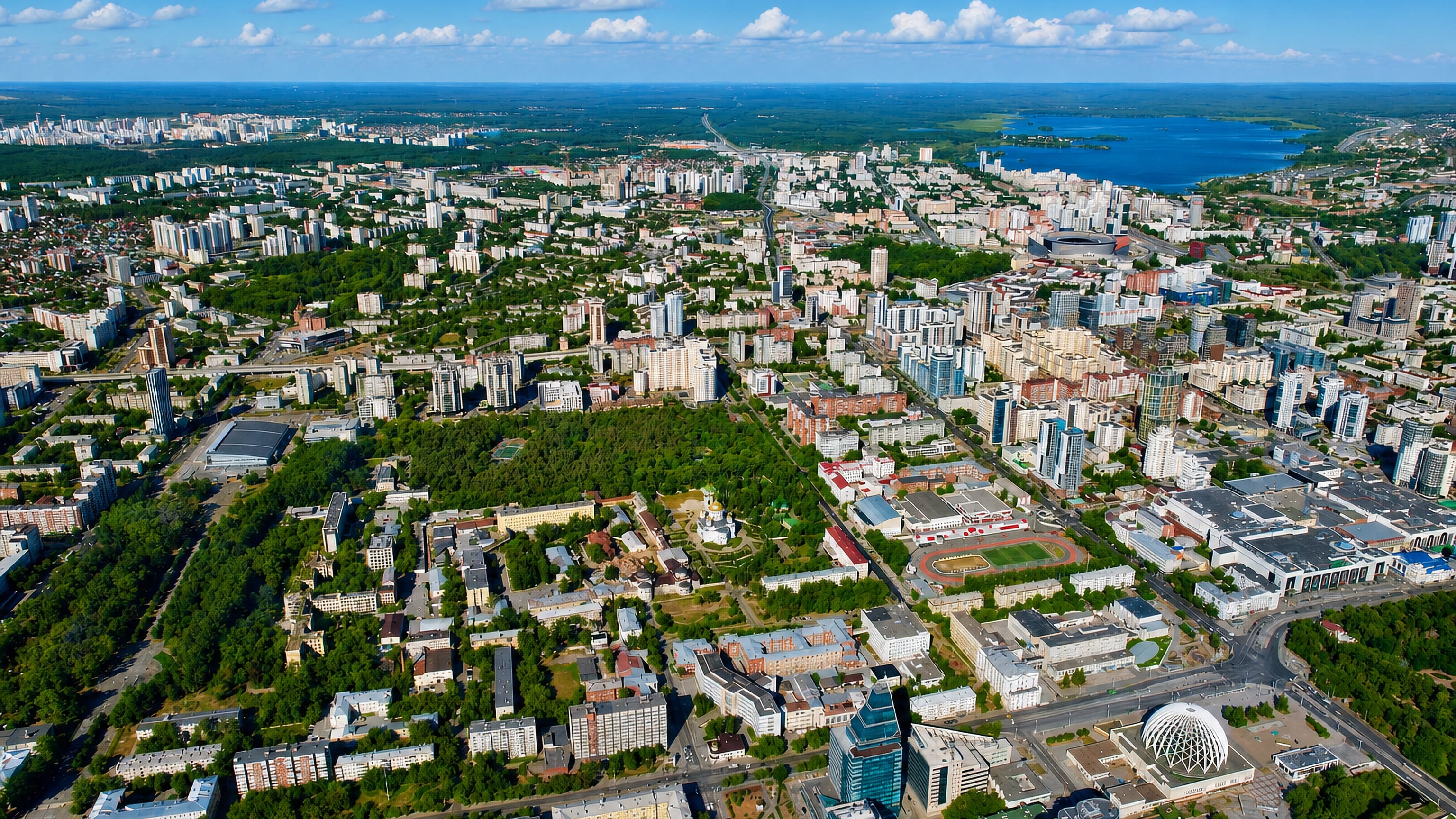 Aerial view over Leninsky district, Yekaterinburg, with the domed circus, a stadium and a lake beyond.