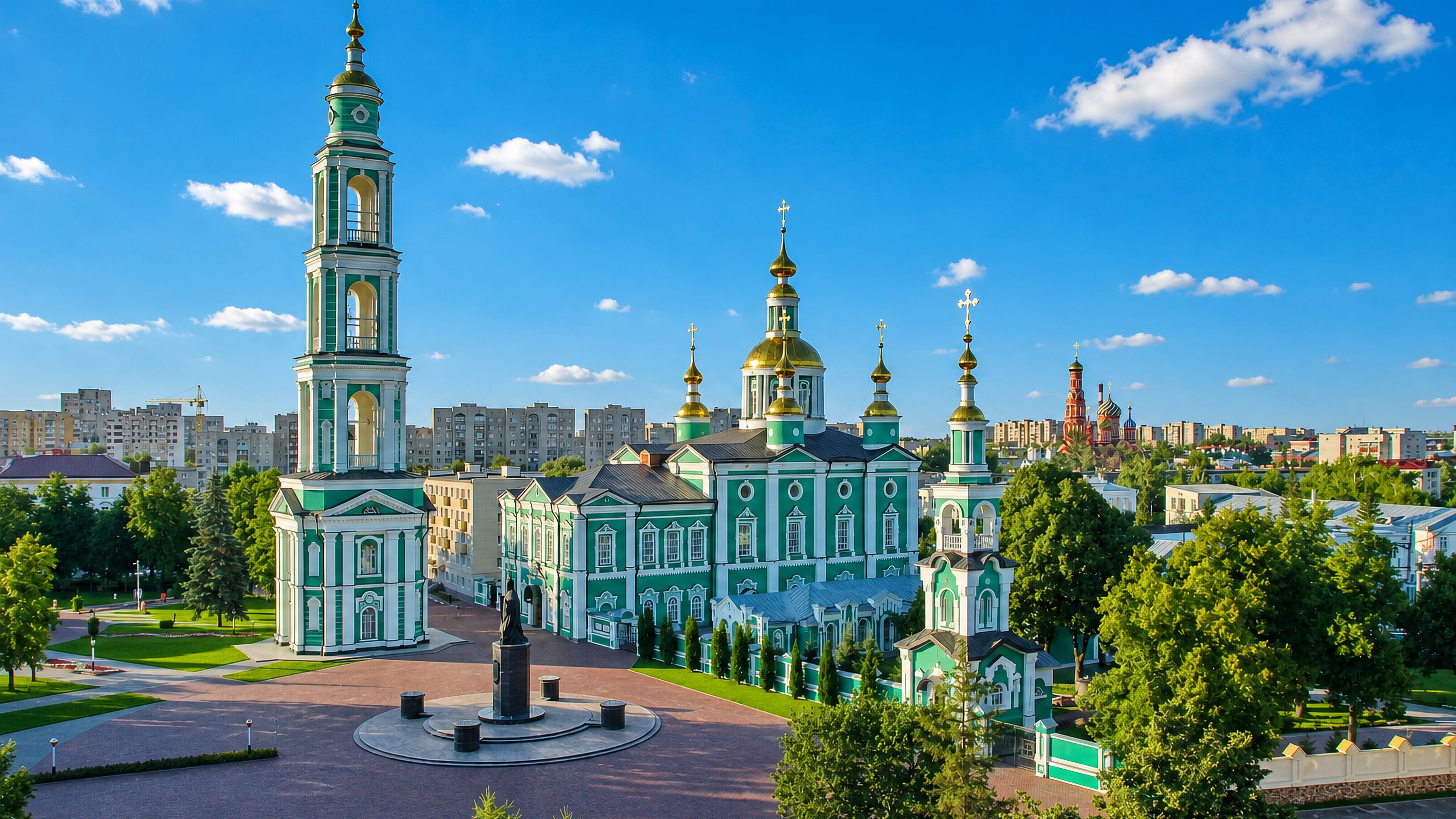 Tambov's green-and-white Transfiguration Cathedral and bell tower above a paved square and city rooftops.