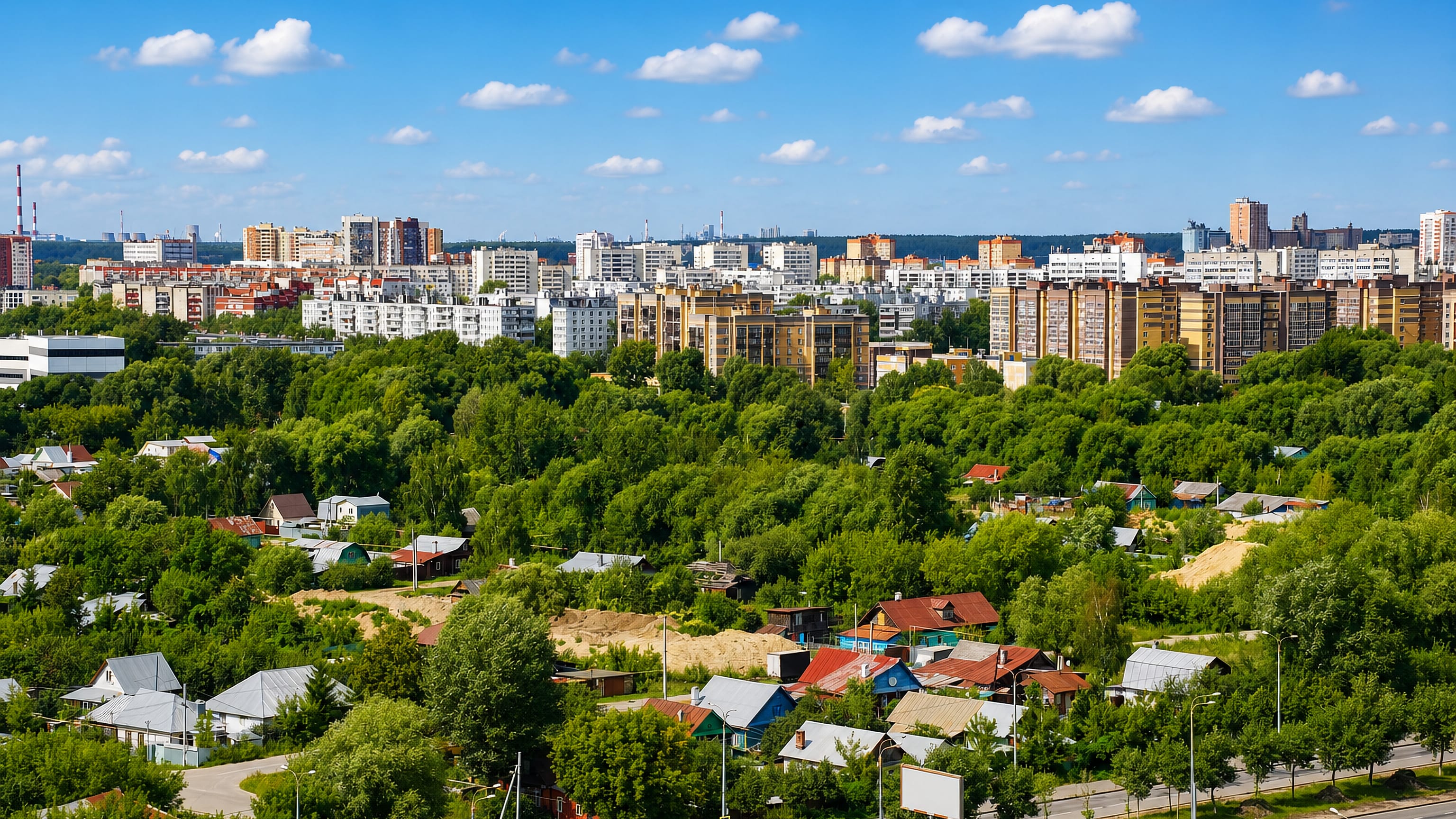 Aerial view over Kazan's Kirovsky City District, wooden cottages and greenery below rows of mid-rise apartment blocks.