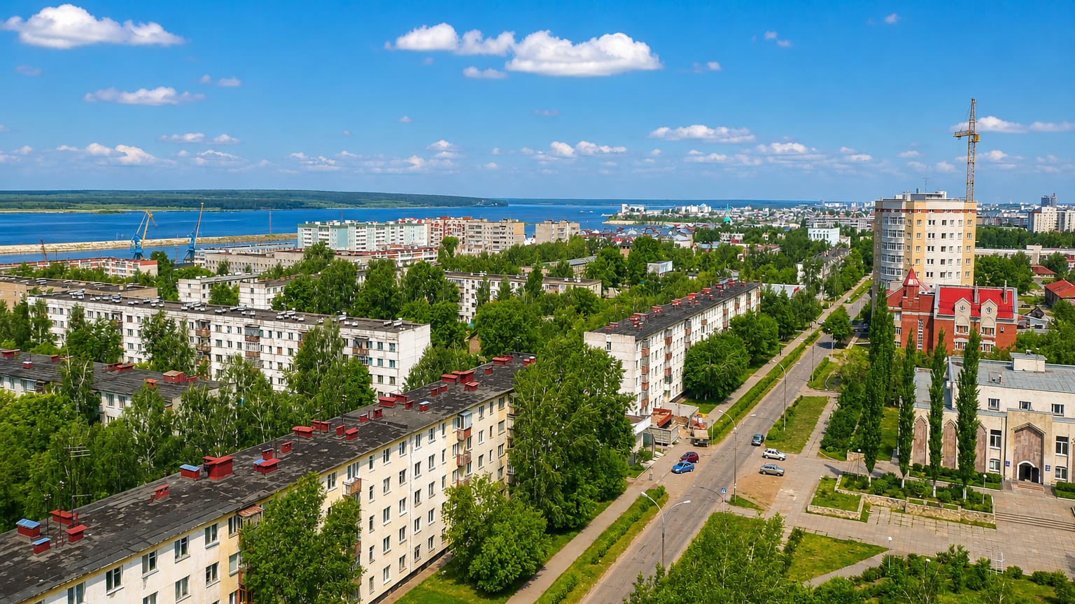 Aerial view over Naberezhnye Chelny's Soviet-era apartment blocks and tree-lined avenues toward the Kama River.