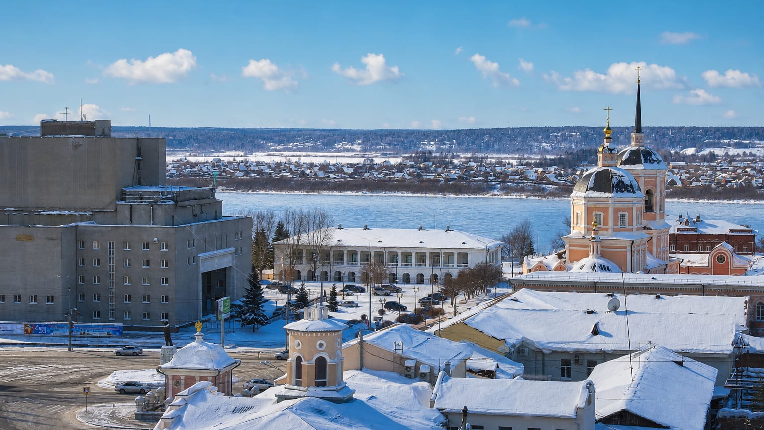 Snow-covered rooftops and the pink Epiphany Cathedral above the Tom River in wintertime Tomsk, Russia.