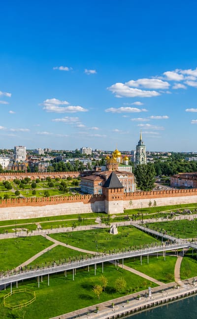The red-brick walls and towers of Tula Kremlin with its golden-domed cathedral, framed by green riverside parkland