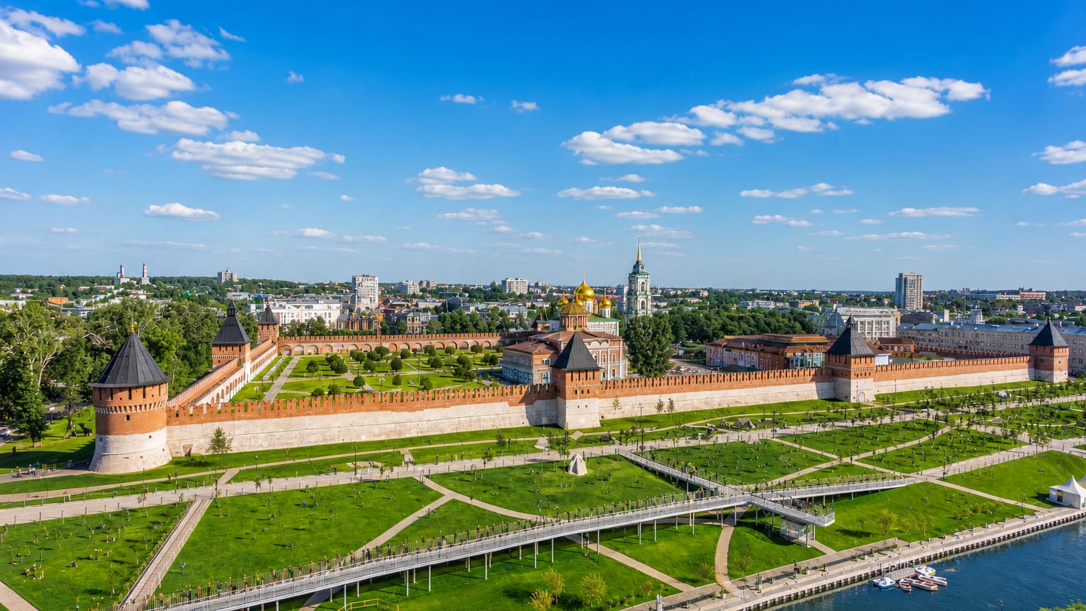 The red-brick walls and towers of Tula Kremlin with its golden-domed cathedral, framed by green riverside parkland
