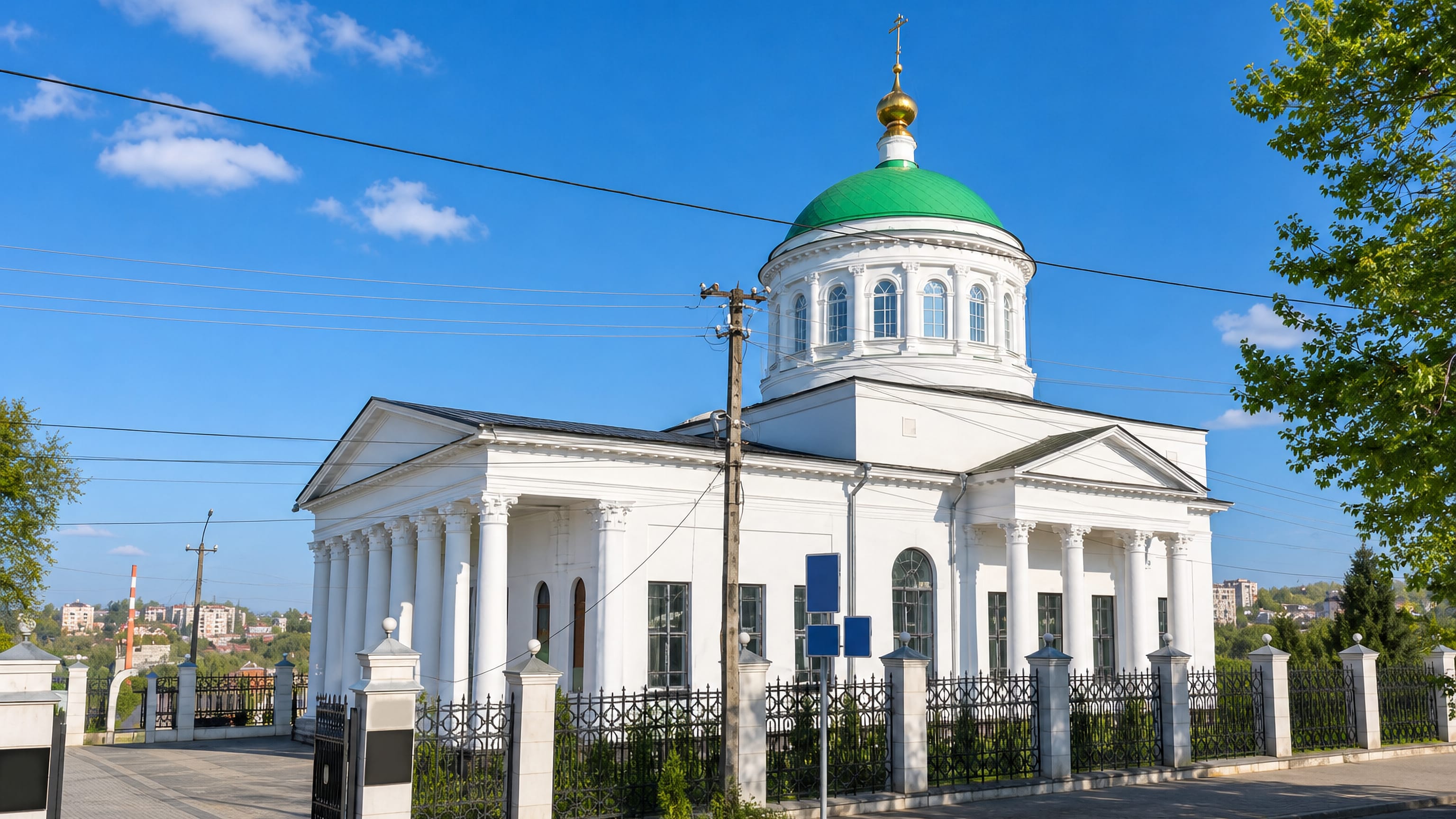 White neoclassical Orthodox church with a green dome and gilded cross in Rzhev, Tver Oblast.
