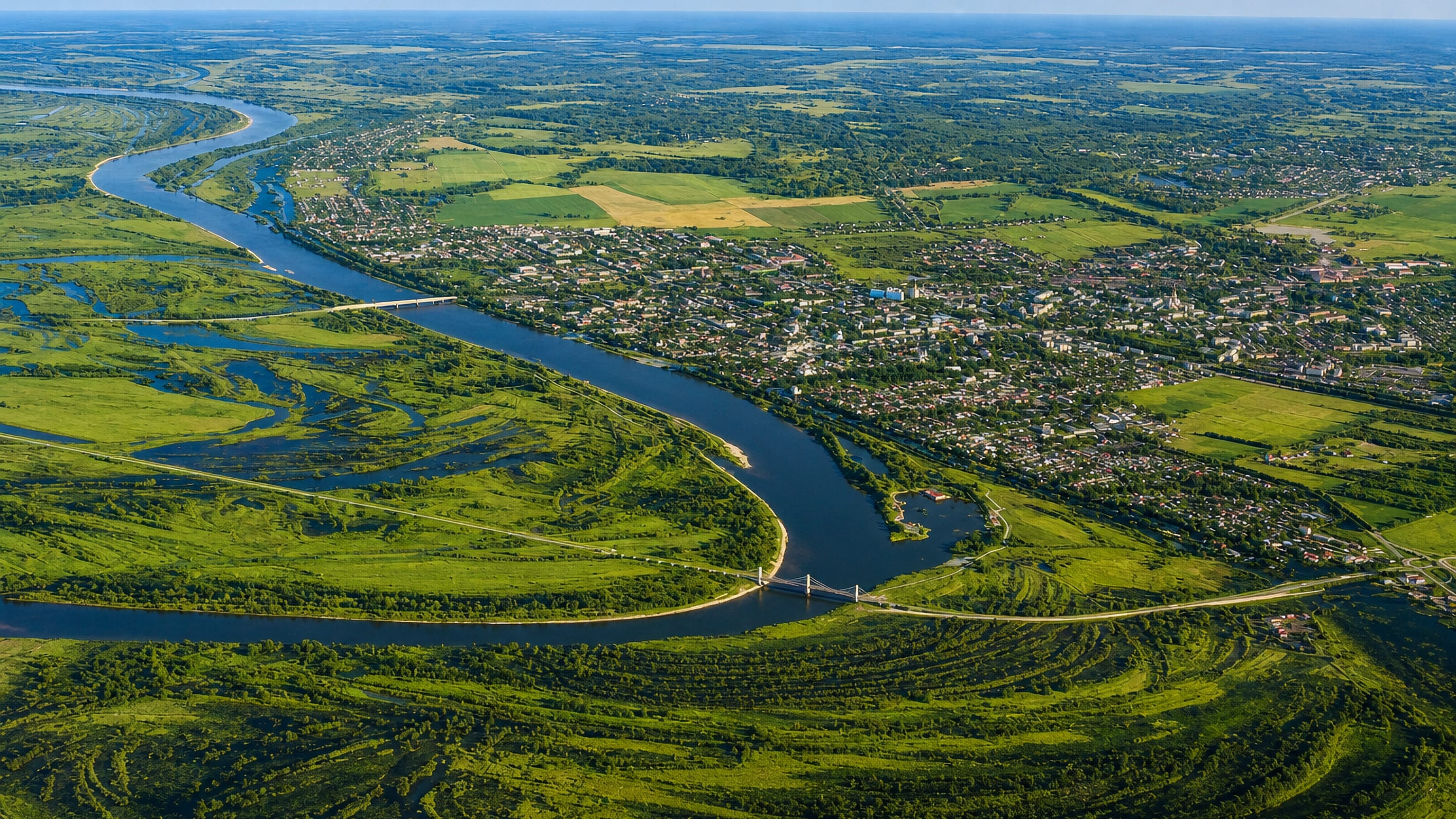 Aerial view of Murom, Russia, on the Oka River, a cable-stayed bridge crossing its green floodplain.