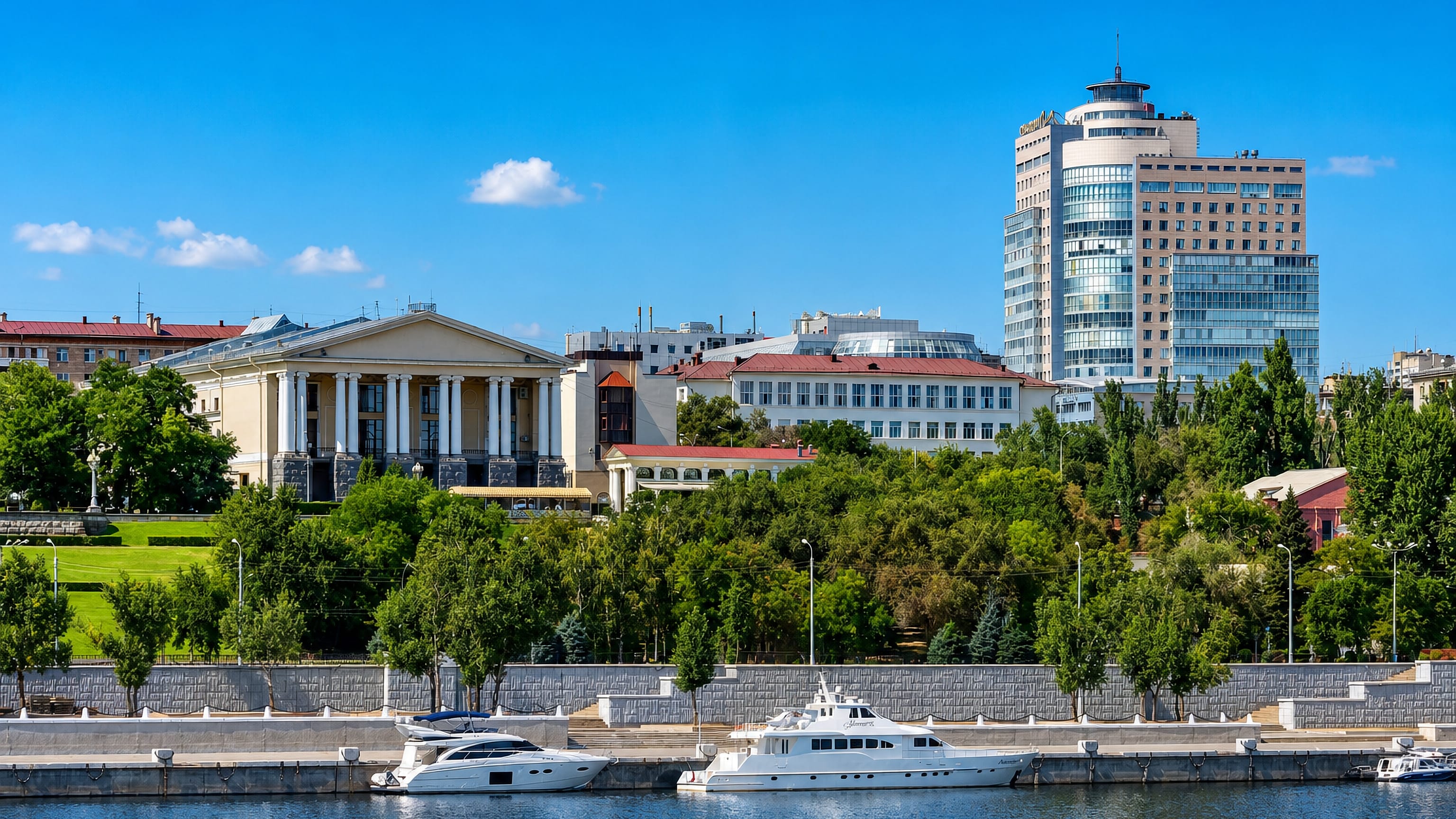 Volga embankment in Volgograd's Tsentralny district with moored yachts, a colonnaded hall and a glass tower