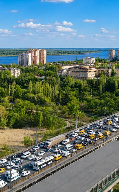 Volgograd's curved sail-shaped riverside tower on the Volga with a busy bridge in the Voroshilovsky District.