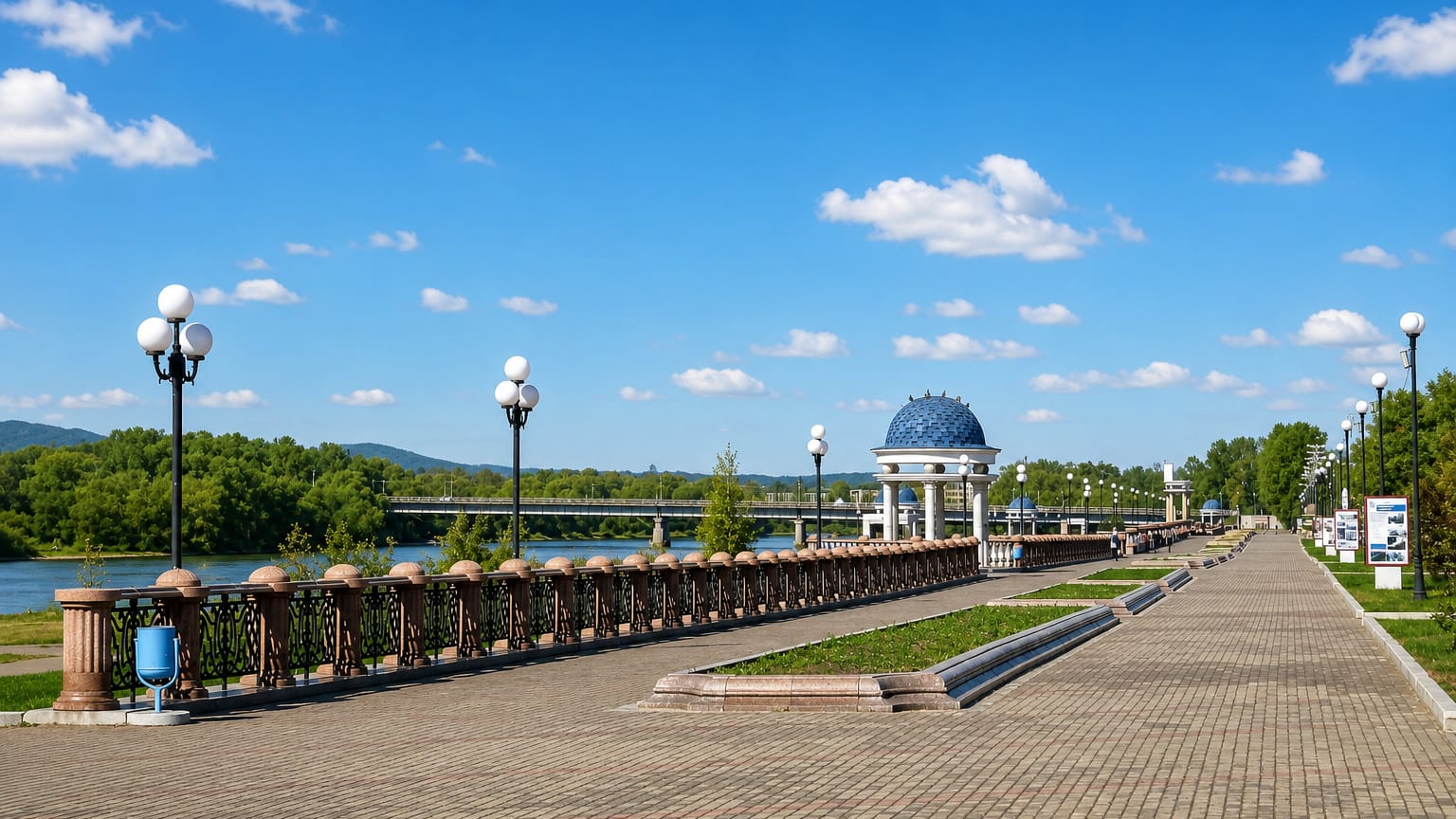 Riverside promenade with a blue-domed rotunda and ornate lamps along the Bira River in Birobidzhan, Russia.